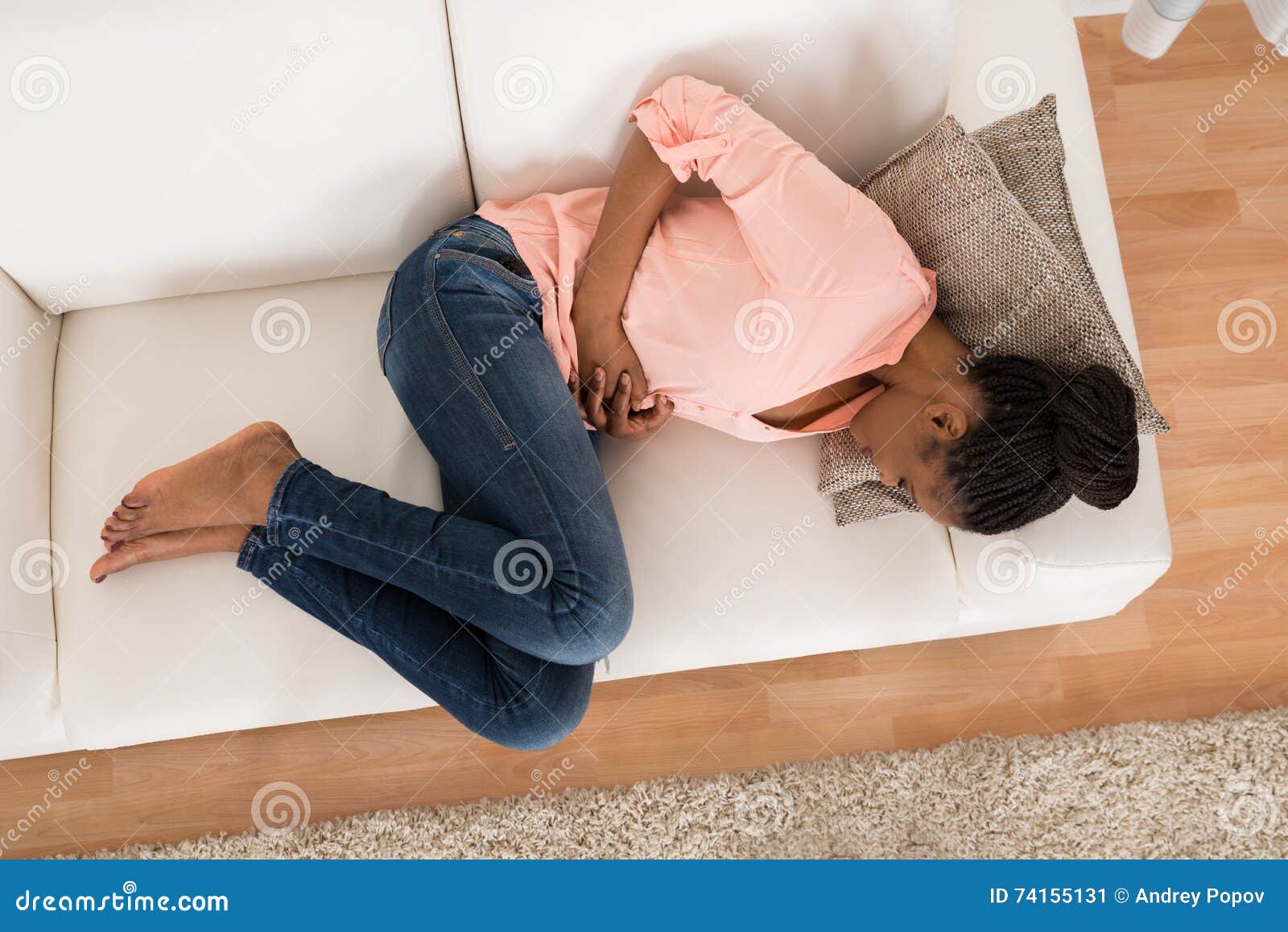 woman with stomach ache lying on sofa