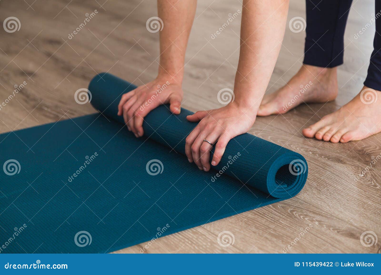 woman unrolling her yoga mat in a studio