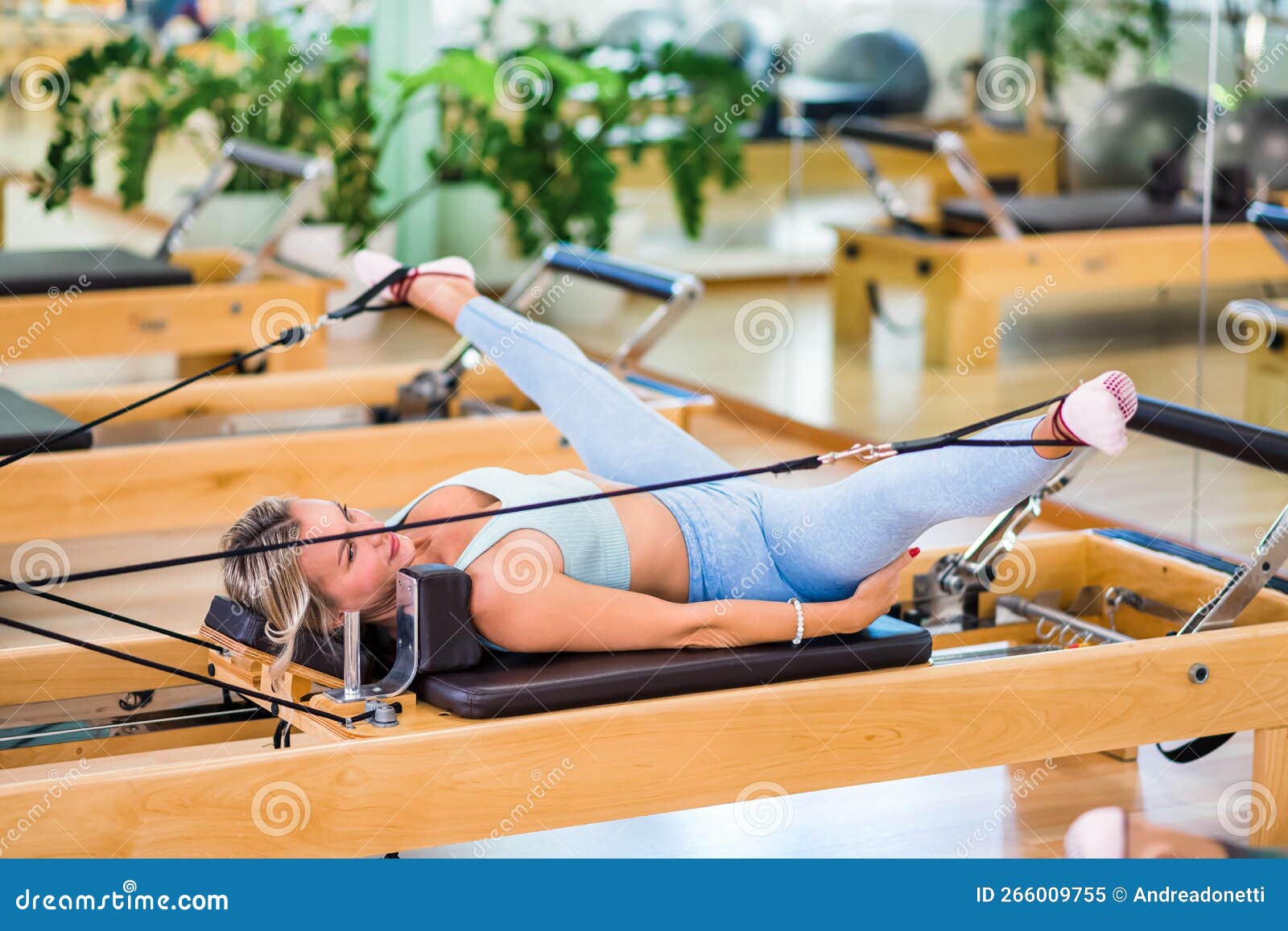 woman stretching legs on pilates reformer