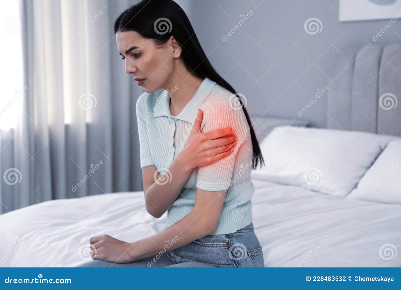 Woman Suffering from Shoulder Pain on Bed at Home Stock Photo Image