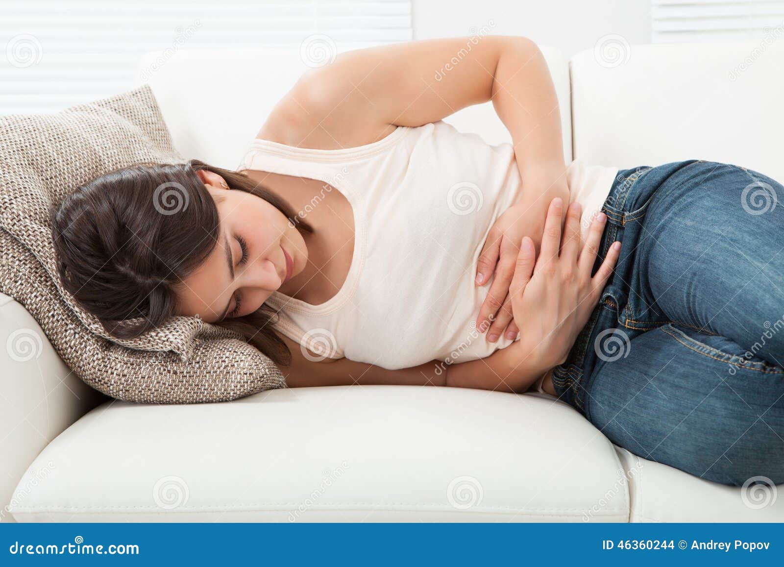 woman suffering from stomachache on sofa