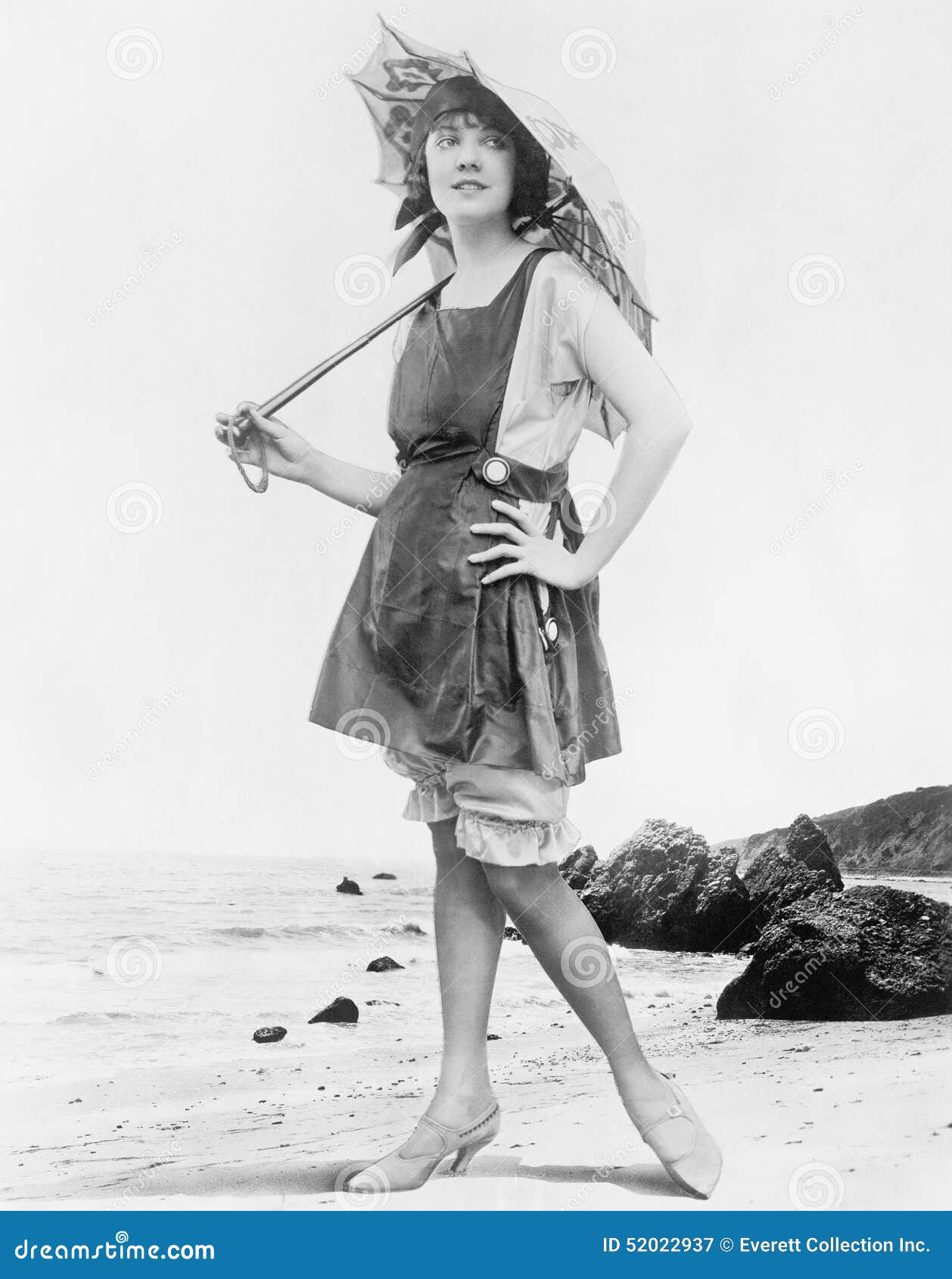 woman with sun umbrella and bathing suit at the beach