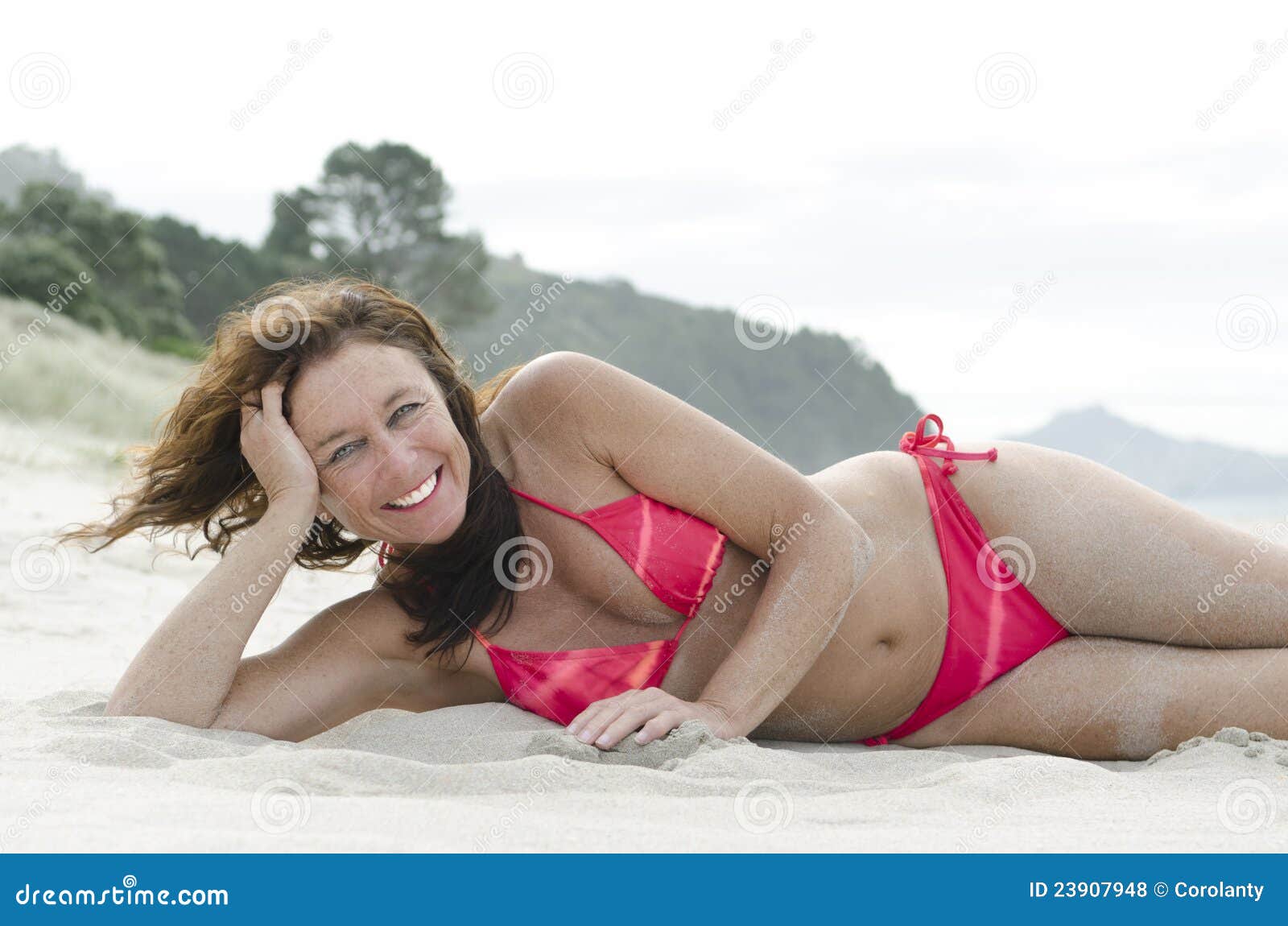 Woman sunbathing on beach stock photo