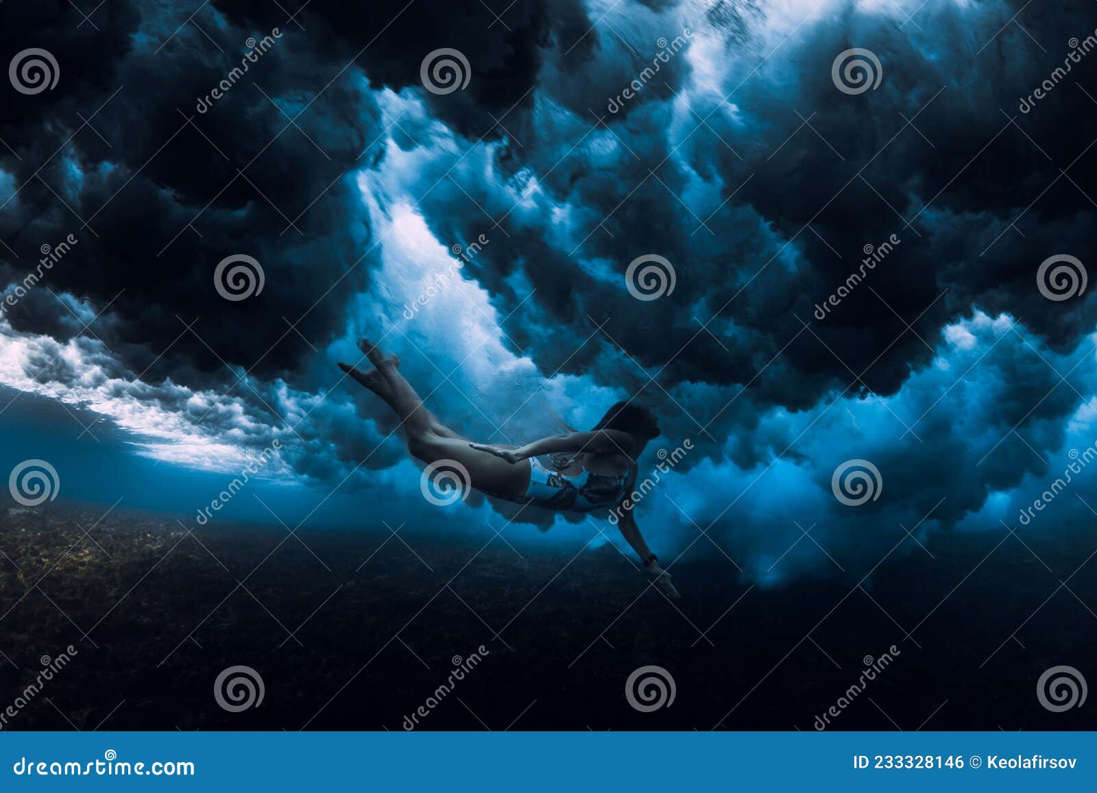 Woman Swim Underwater with Wave. Duck Dive Under Wave Stock Photo