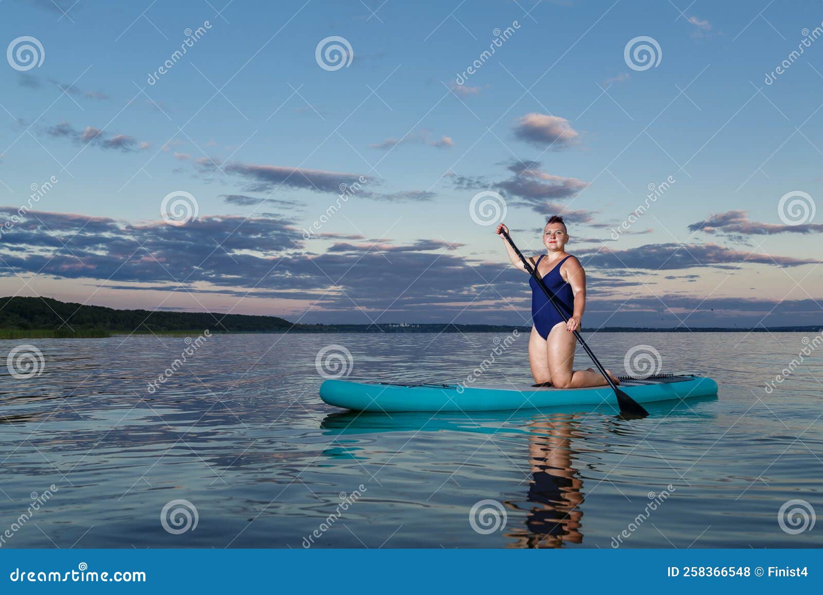 Woman in a Swimsuit Kneeling on a Snowboard in the Evening at Sunset ...