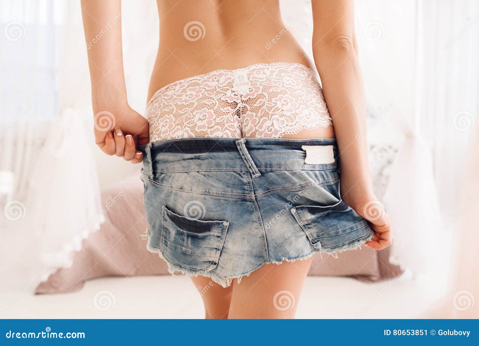 Woman Take Down Her Denim Mini Skirt in Bedroom Stock Image pic image