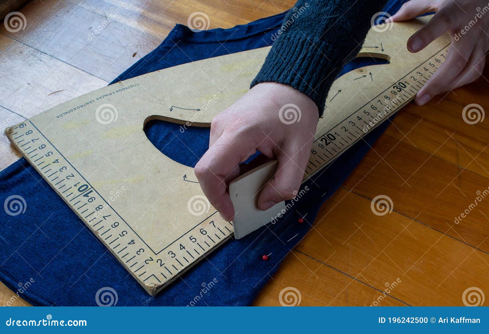 woman takes measurements  of a blue cloth