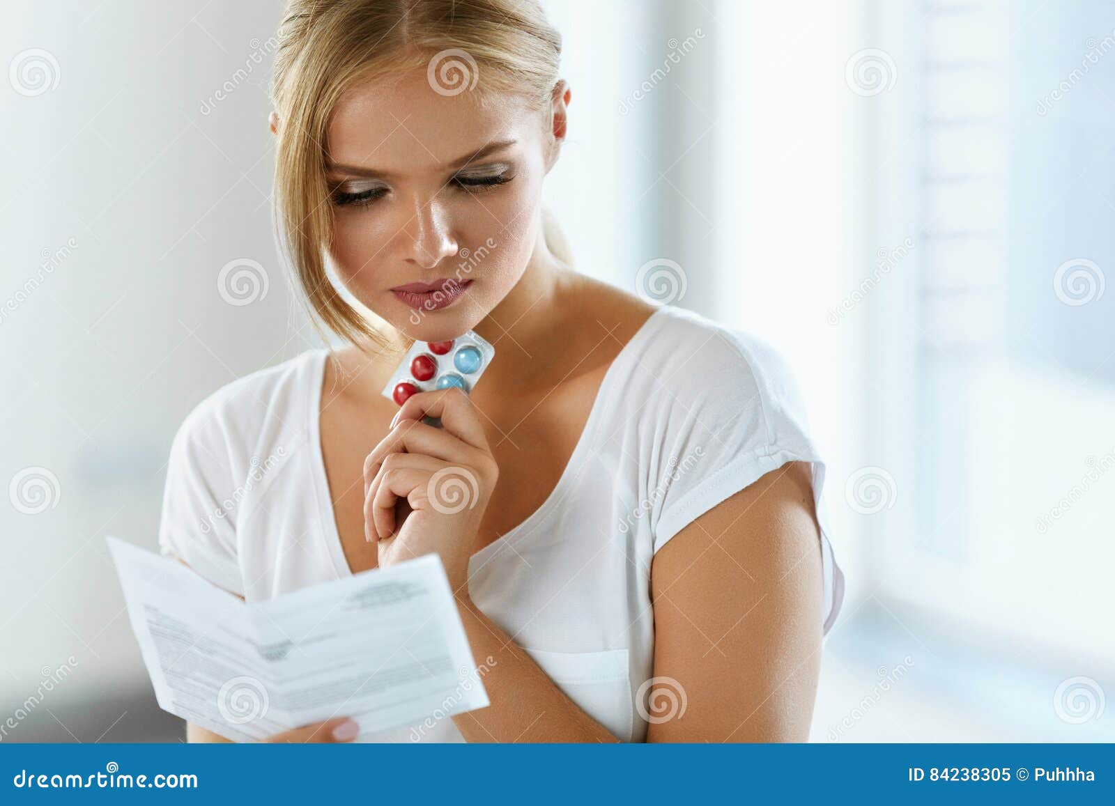 woman taking medicine. female with pills reading instructions