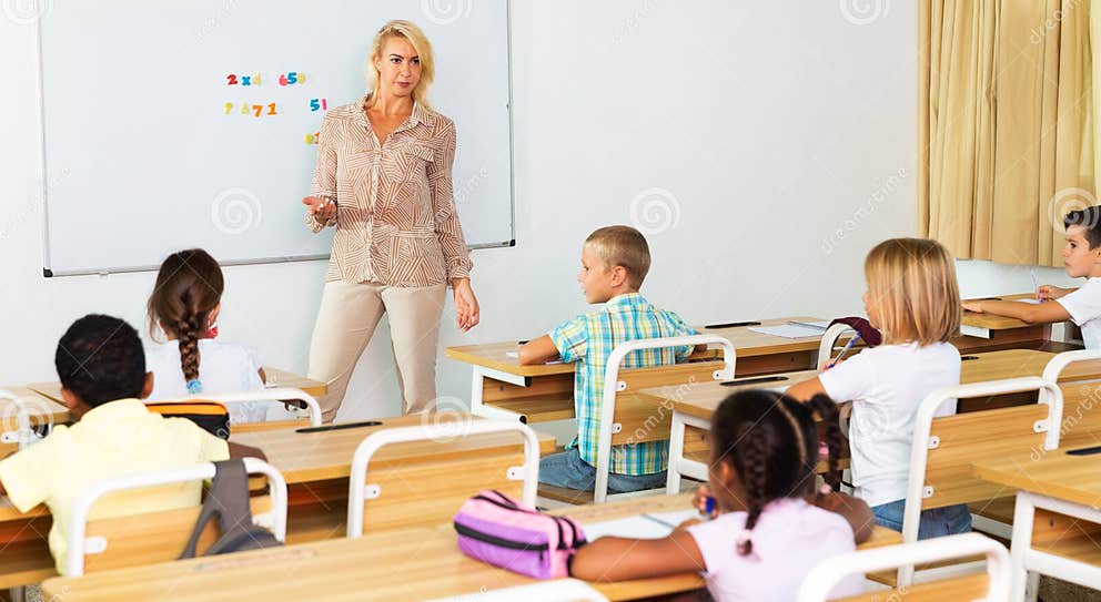Woman Teacher Standing at Whiteboard during Lesson with Tweens Stock Woman Teacher Standing at Whiteboard during Lesson with Tweens Stock