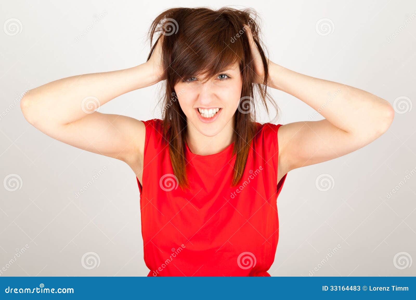 The woman is tearing her hair. The young woman is tearing her hair