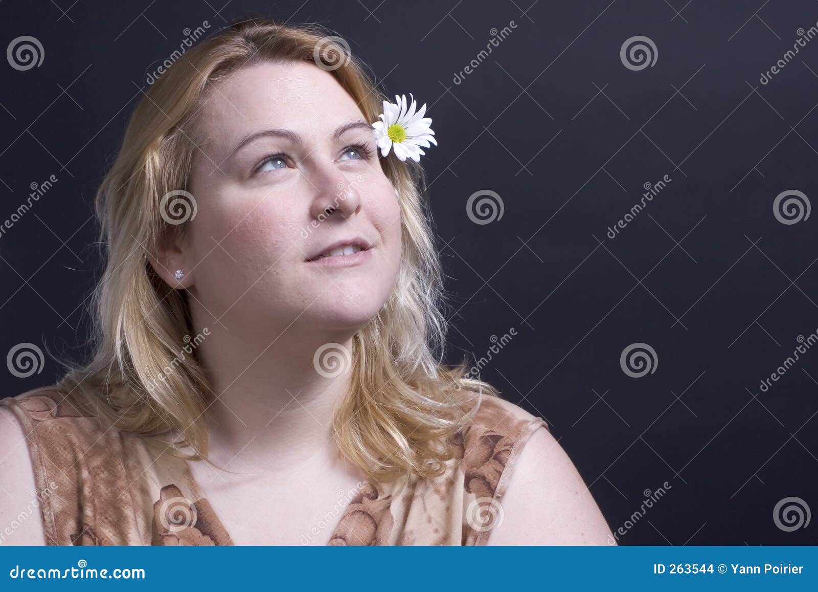 Woman thinking about flower. Woman looking up at the heaven thinking about the flower in her hair