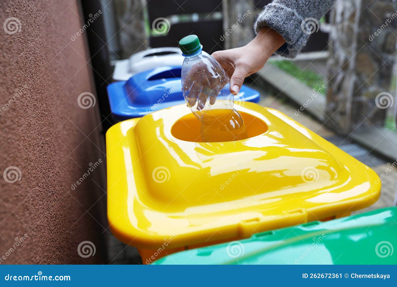 Woman Throwing Plastic Bottle into Recycling Bin Outdoors, Closeup