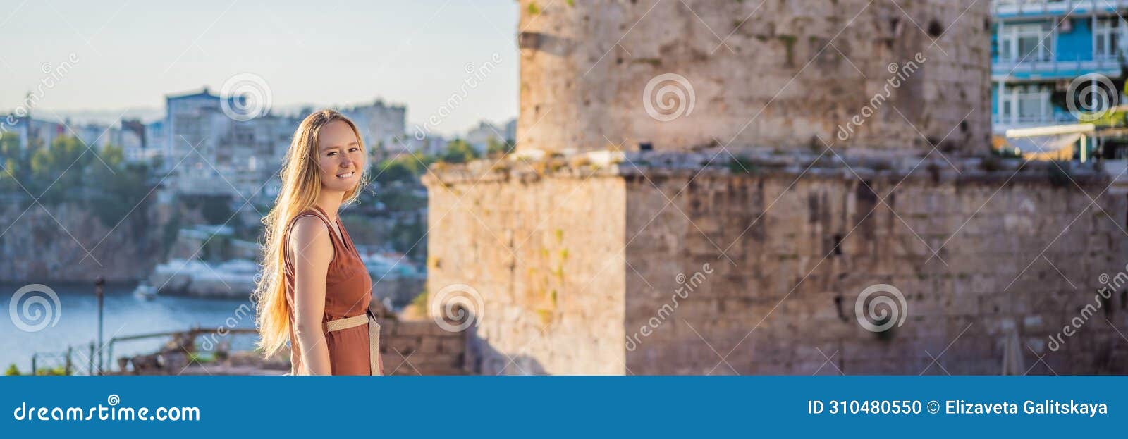 woman tourist on background of hidirlik tower in antalya against the backdrop of the mediterranean bay of the ancient