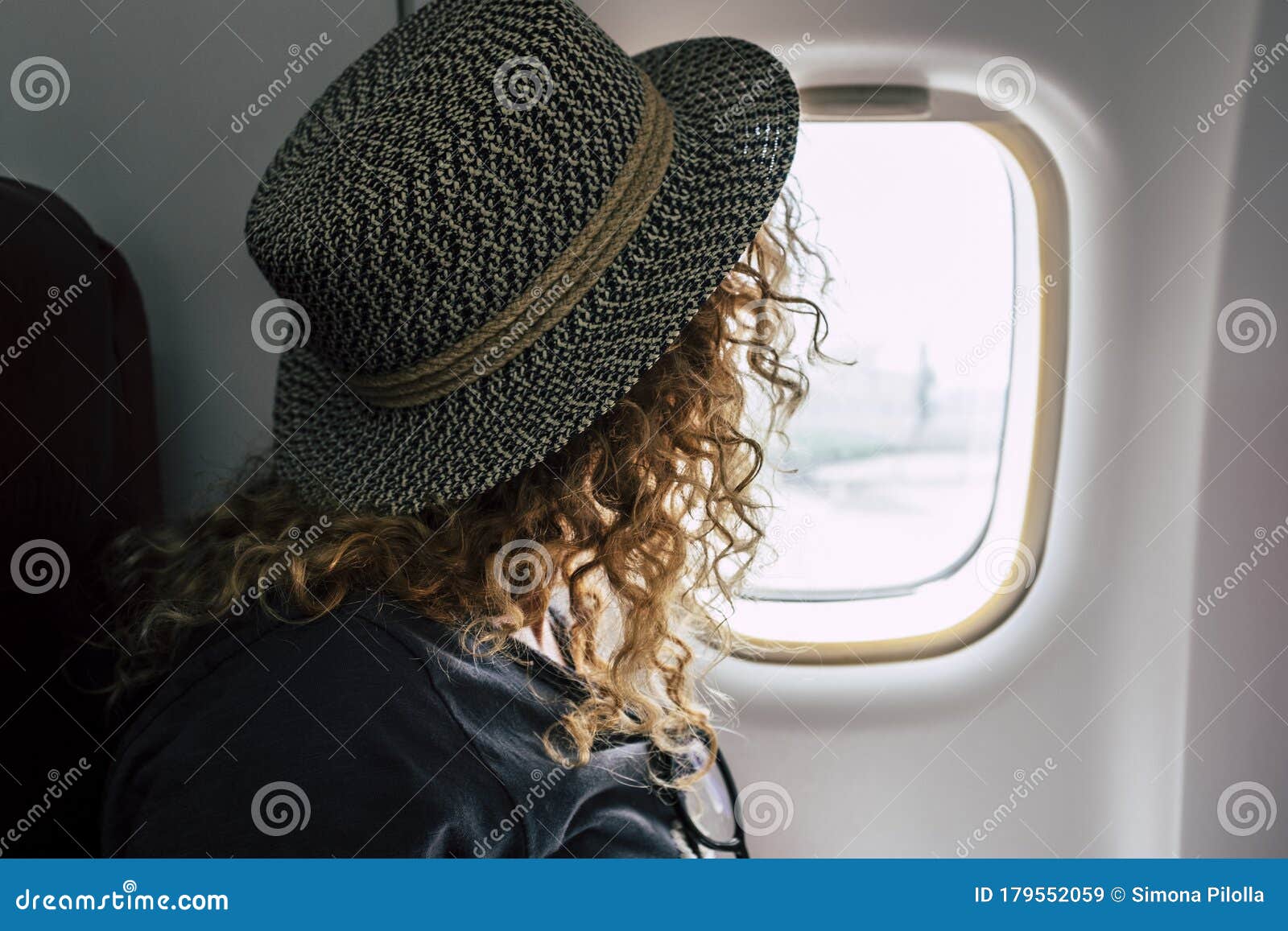woman travel on aircraft flight - fly for business or holiday vacation people inside airplane looking outside from the window -