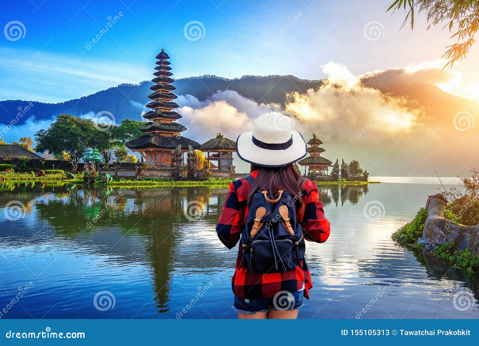 woman traveler with backpack looking to pura ulun danu bratan temple in bali, indonesia.