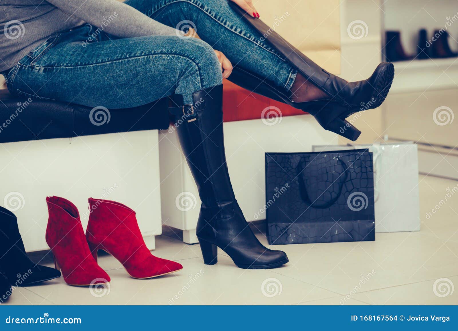 Woman Trying on New Pair of Winter Boots with High Heels while Sitting ...