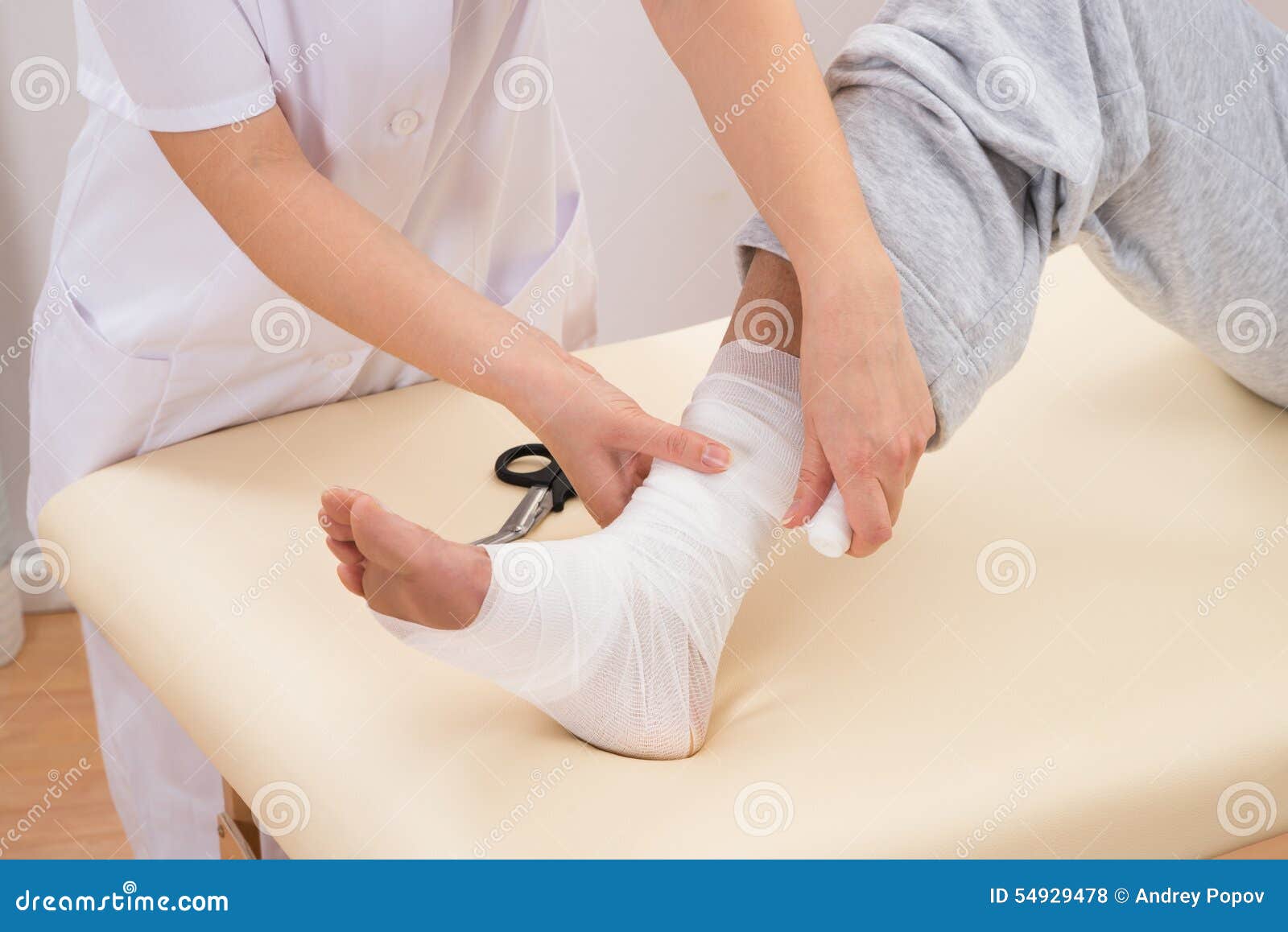 woman tying bandage on patient's foot