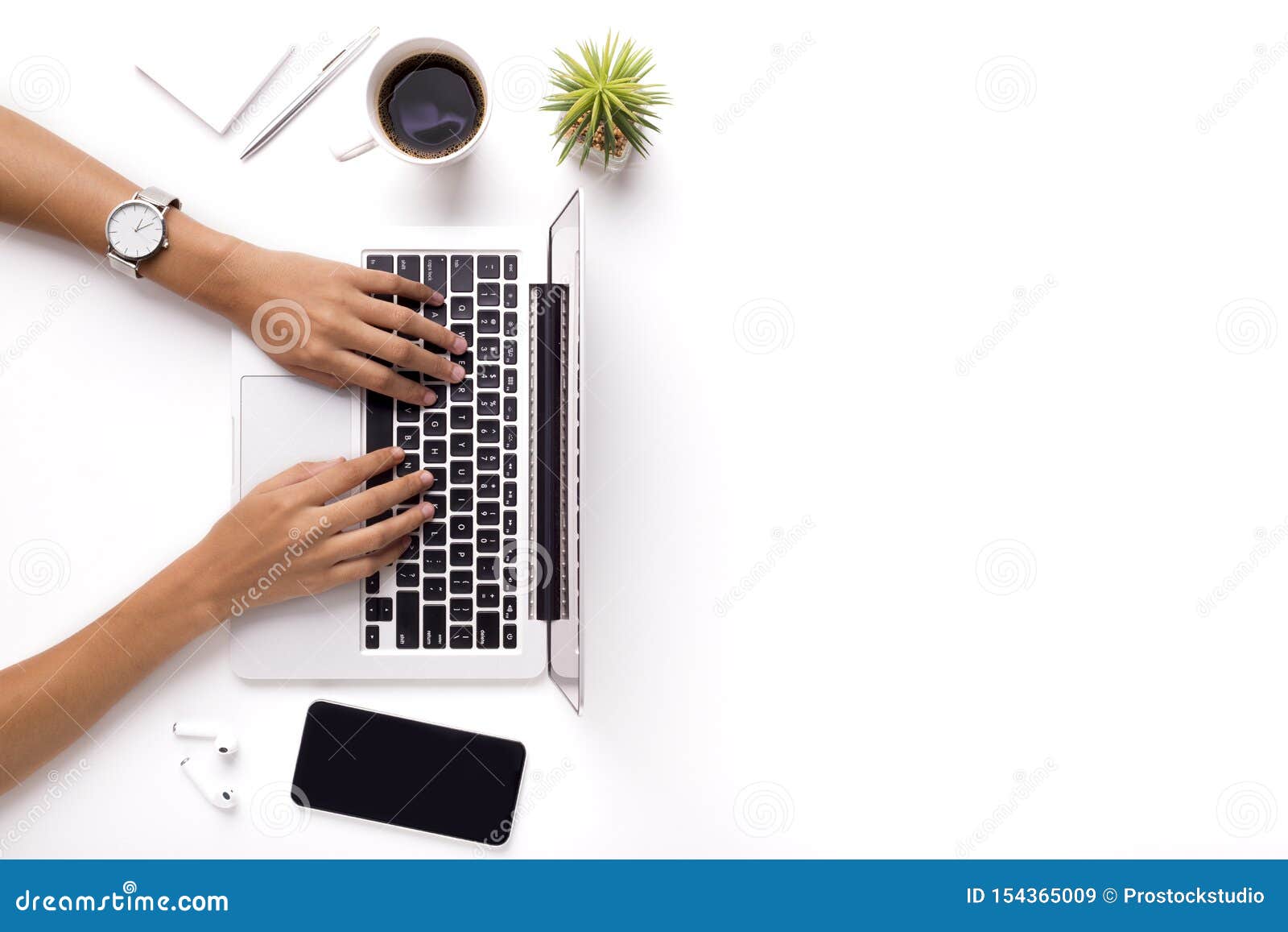 woman typing on laptop on clean white office table with plant