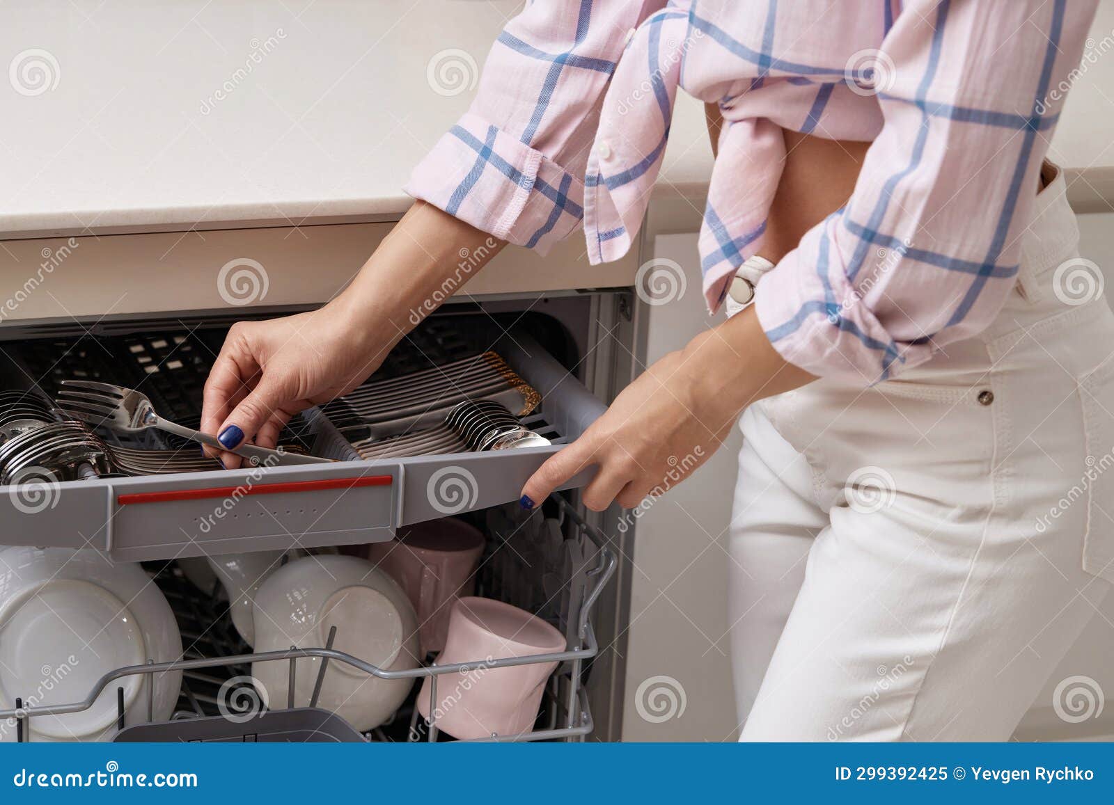 Woman Unloading from Open Dishwasher Machine with Clean Utensils Inside