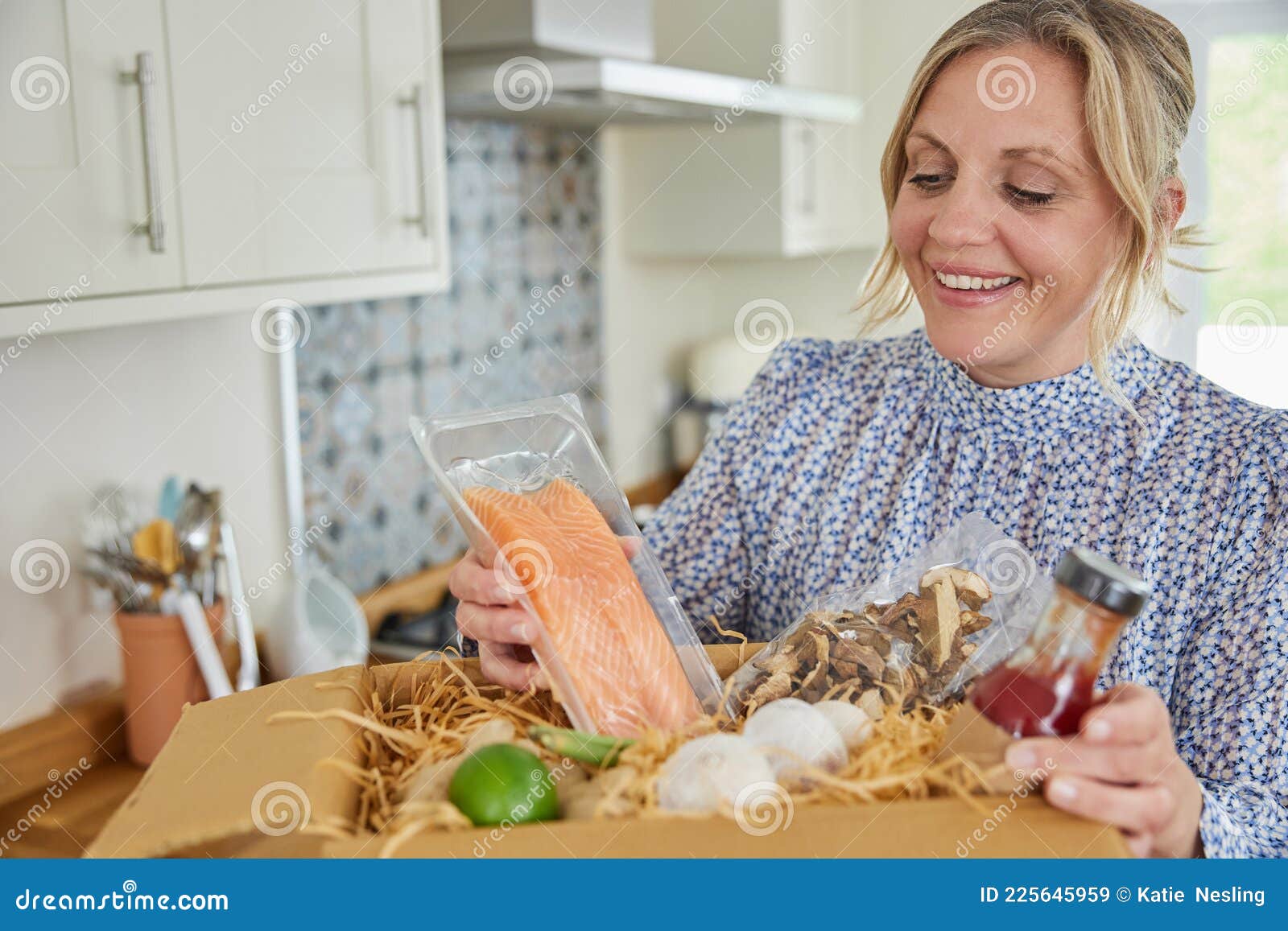 woman unpacking online meal food recipe kit delivered to home