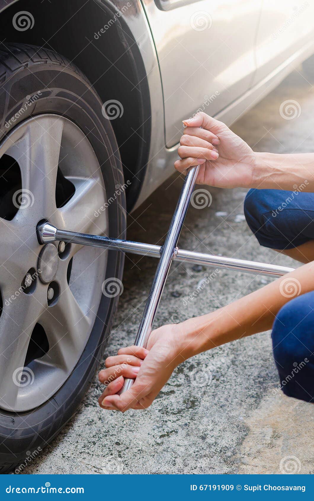 woman are unscrew power to change tire by two hands