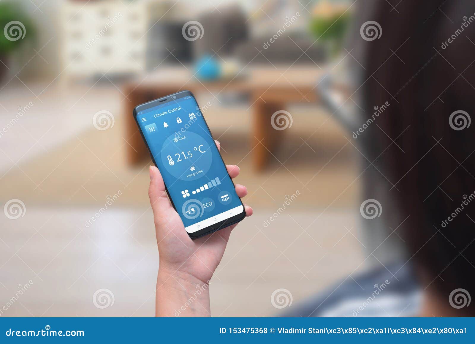 woman use climate control app on a phone in the living room to adjust temperature and ventilation