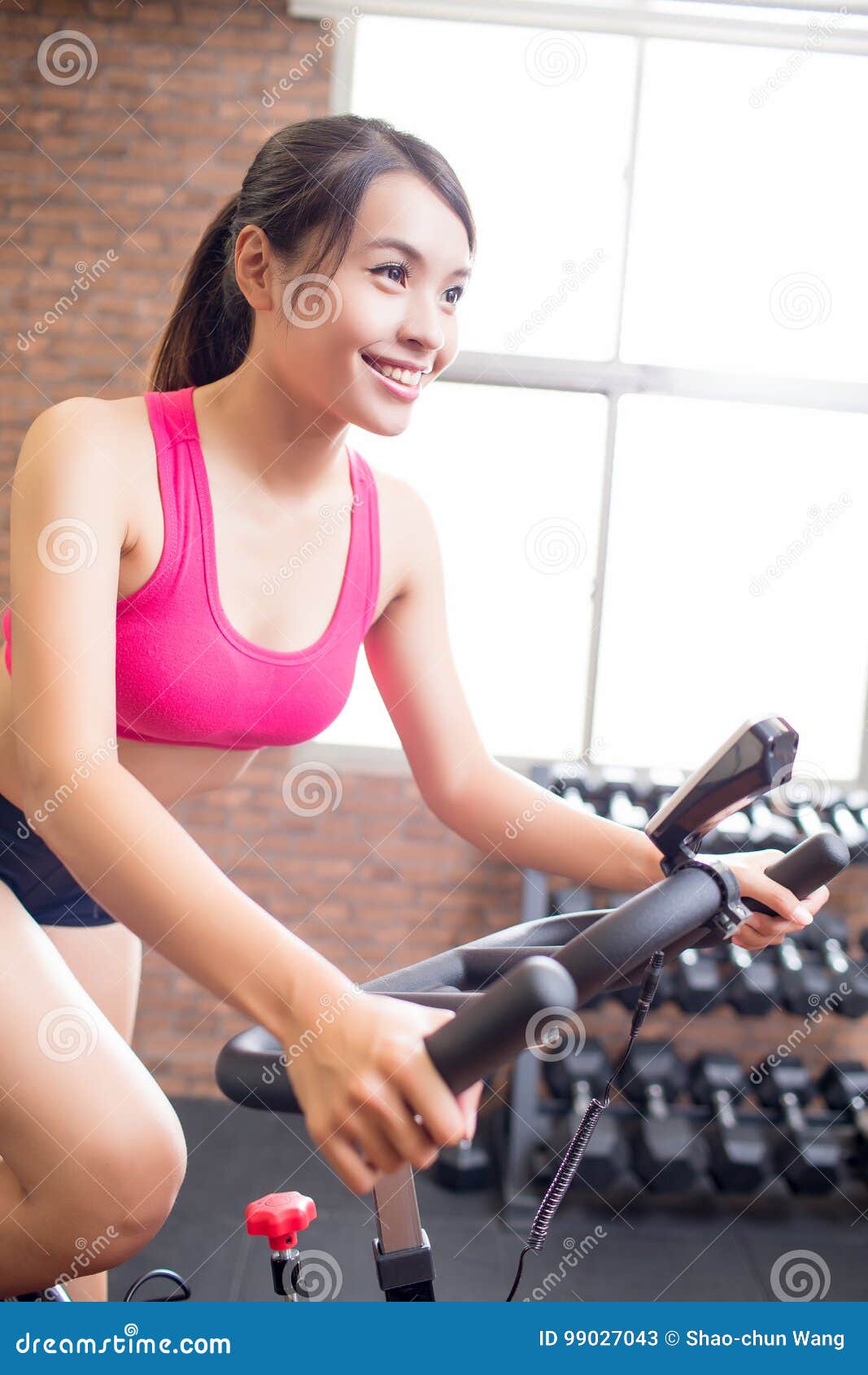 Mature Woman On Cycling Machine In Gym Smiling Portrait High