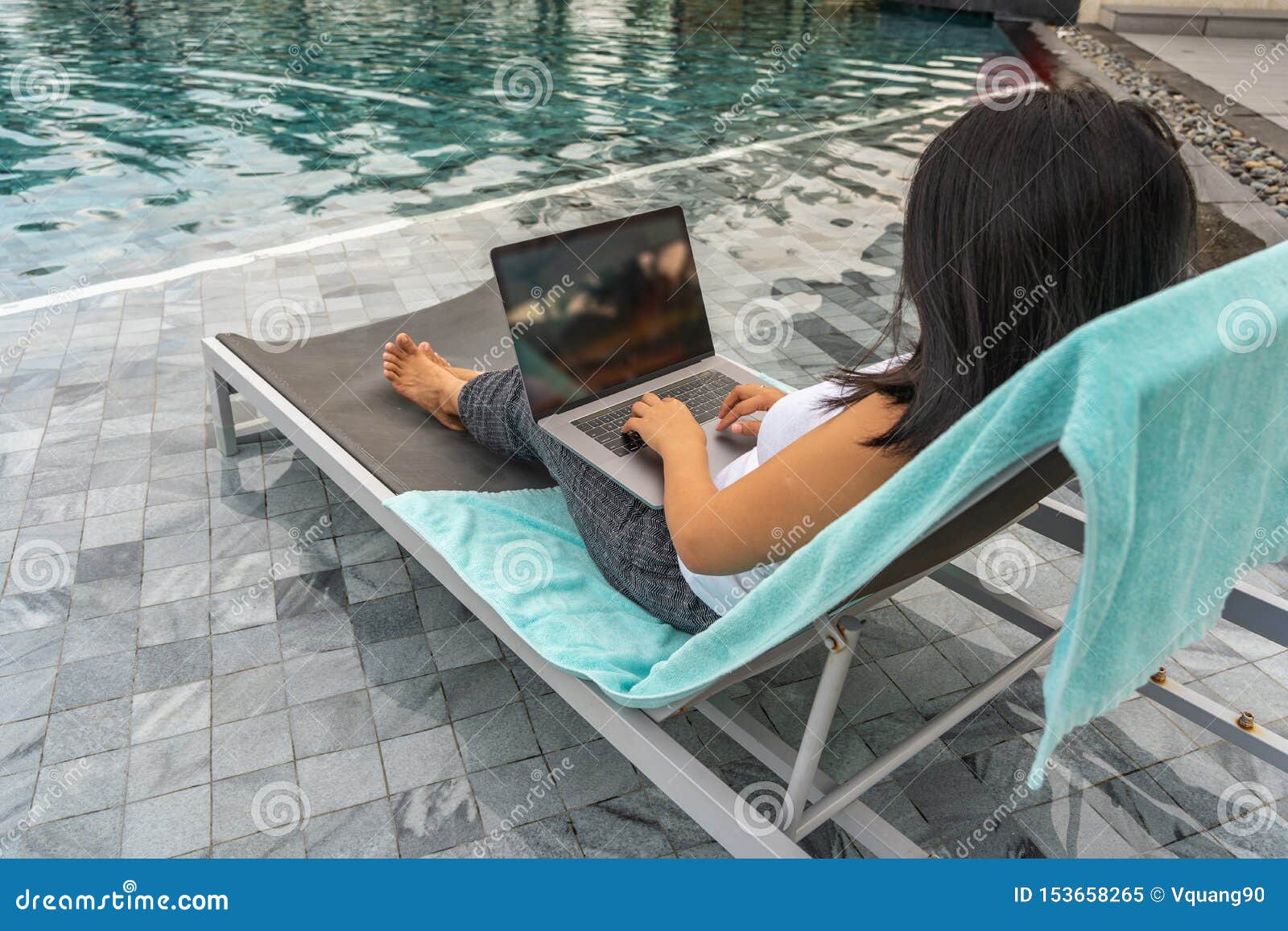 Woman Using Laptop while Sitting on Bench at Swimming Pool Stock Image