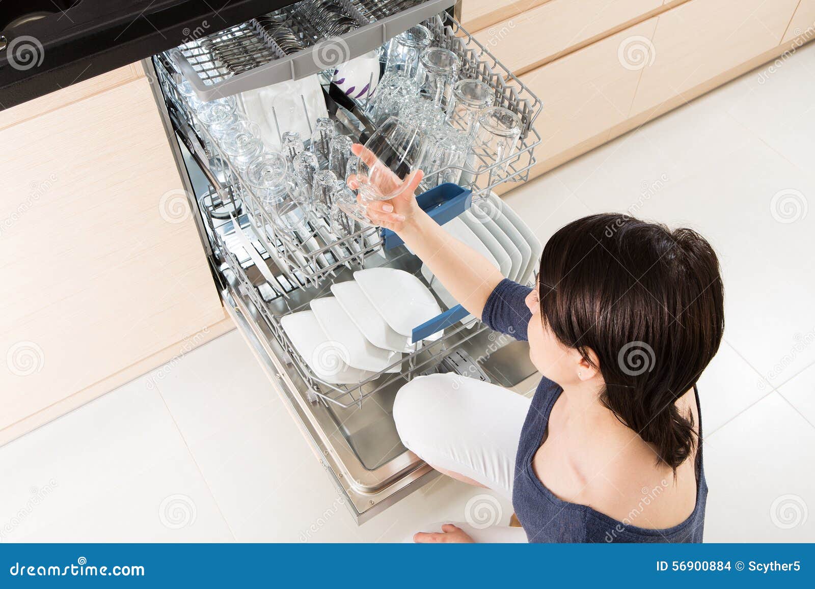 Woman Using a Dishwasher in a Modern Kitchen. Stock Photo Image of