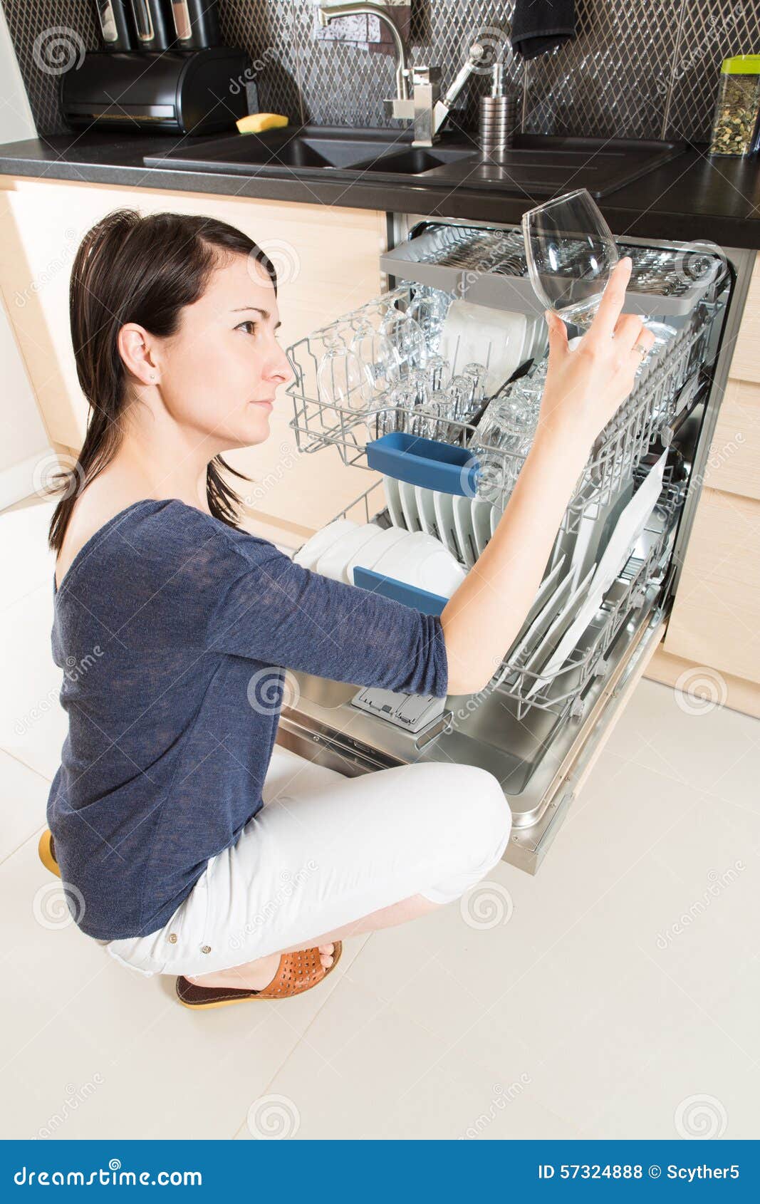 Woman Using a Dishwasher in a Modern Kitchen. Stock Photo Image of