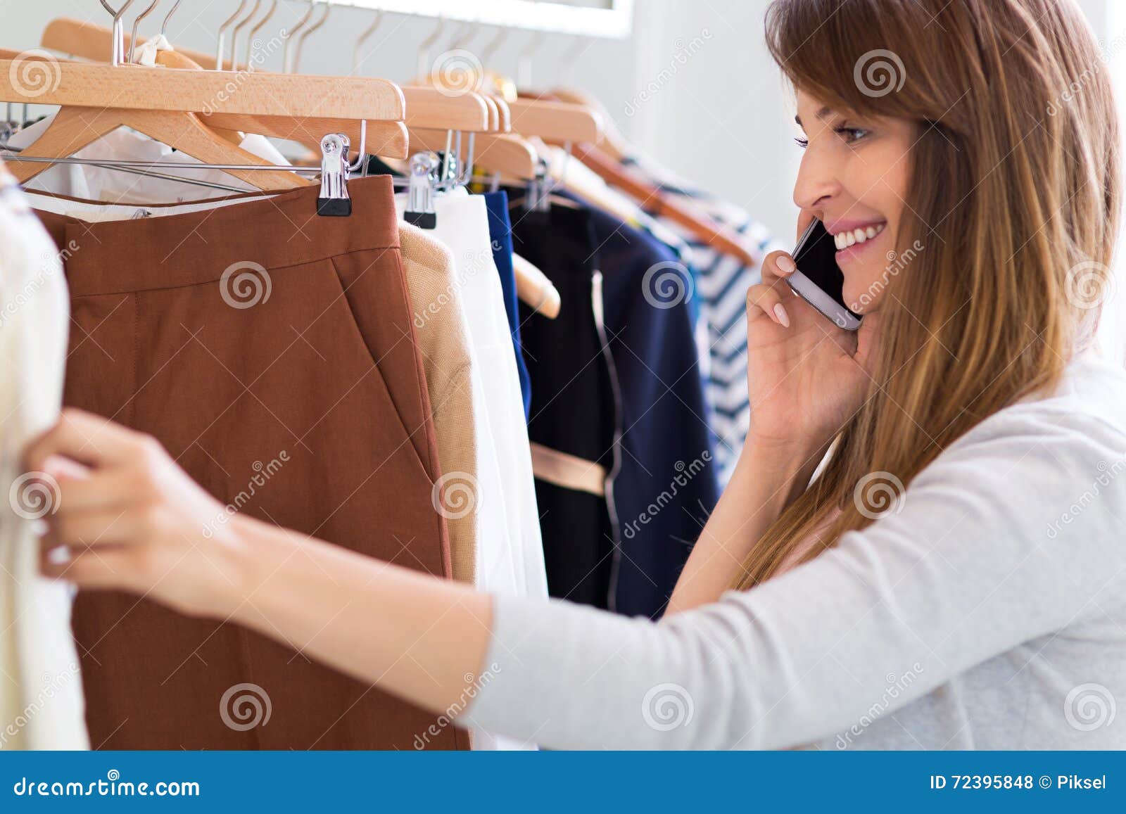 Woman Using Mobile Phone in Clothes Shop Stock Photo - Image of ...