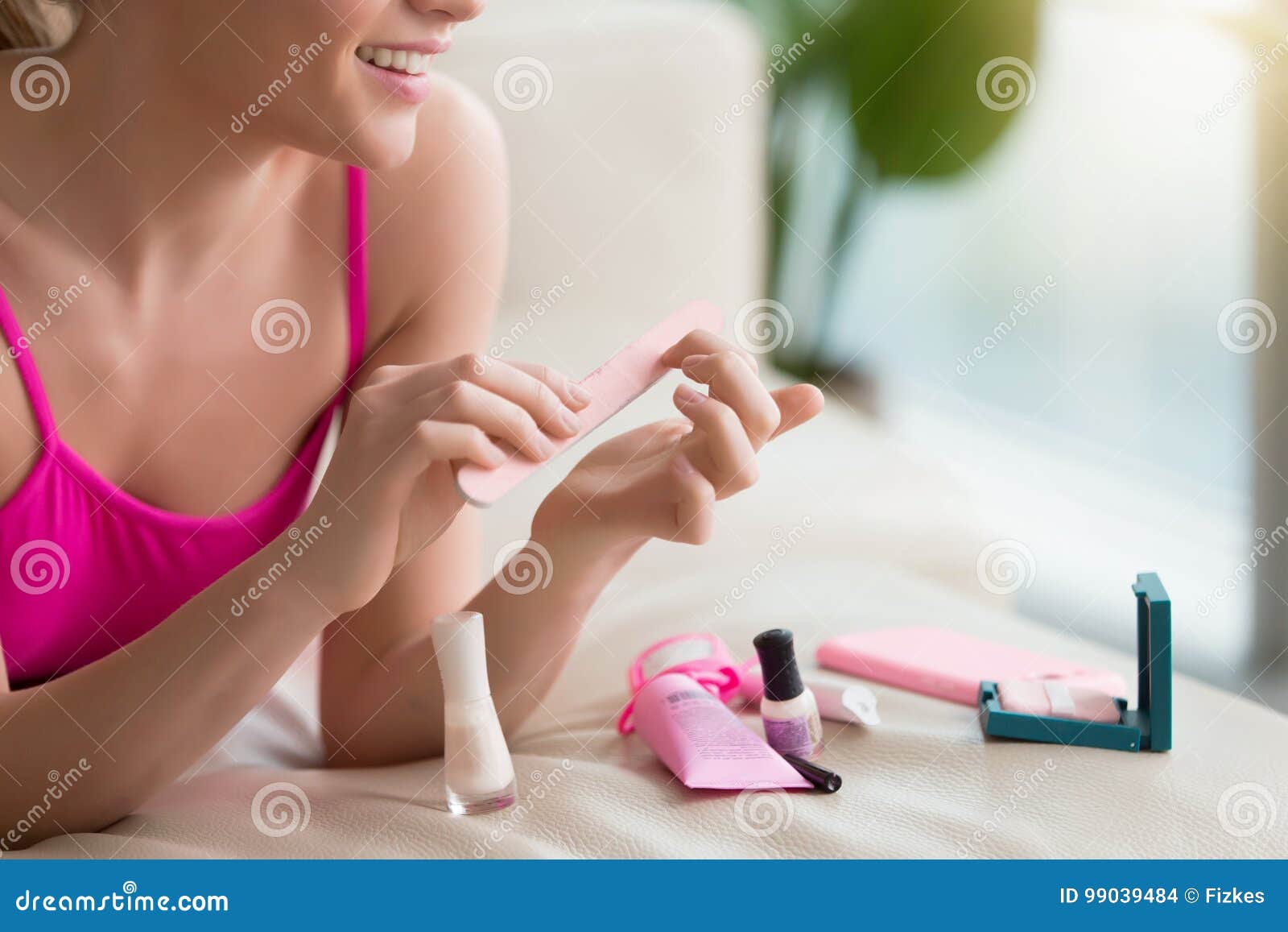 woman using nail buffer when doing manicure