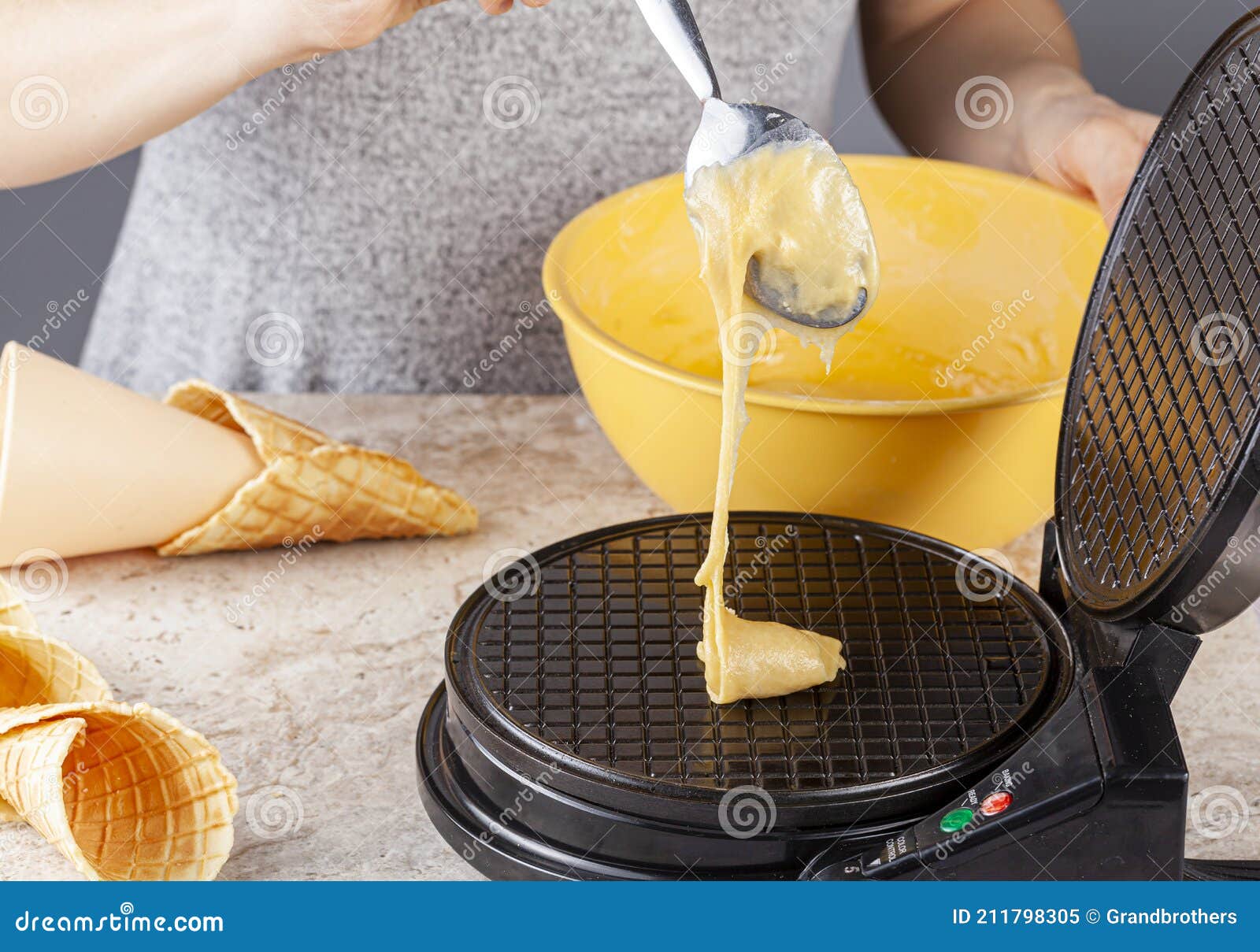 A Woman is Using a Non Stick Electrical Waffle Cone Maker To Make