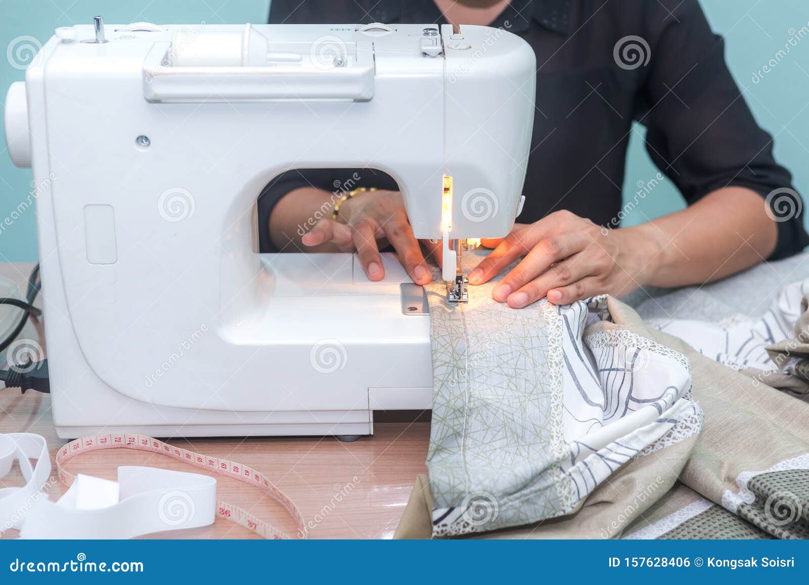 Woman is Using Sewing Machine for Bed Sheets by Oneself Stock Photo