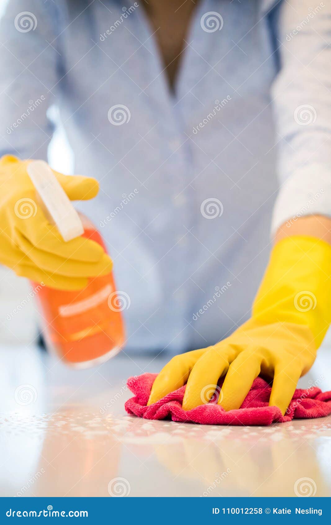 Close Up of Woman Using Spray Polish To Clean Kitchen Surface Stock