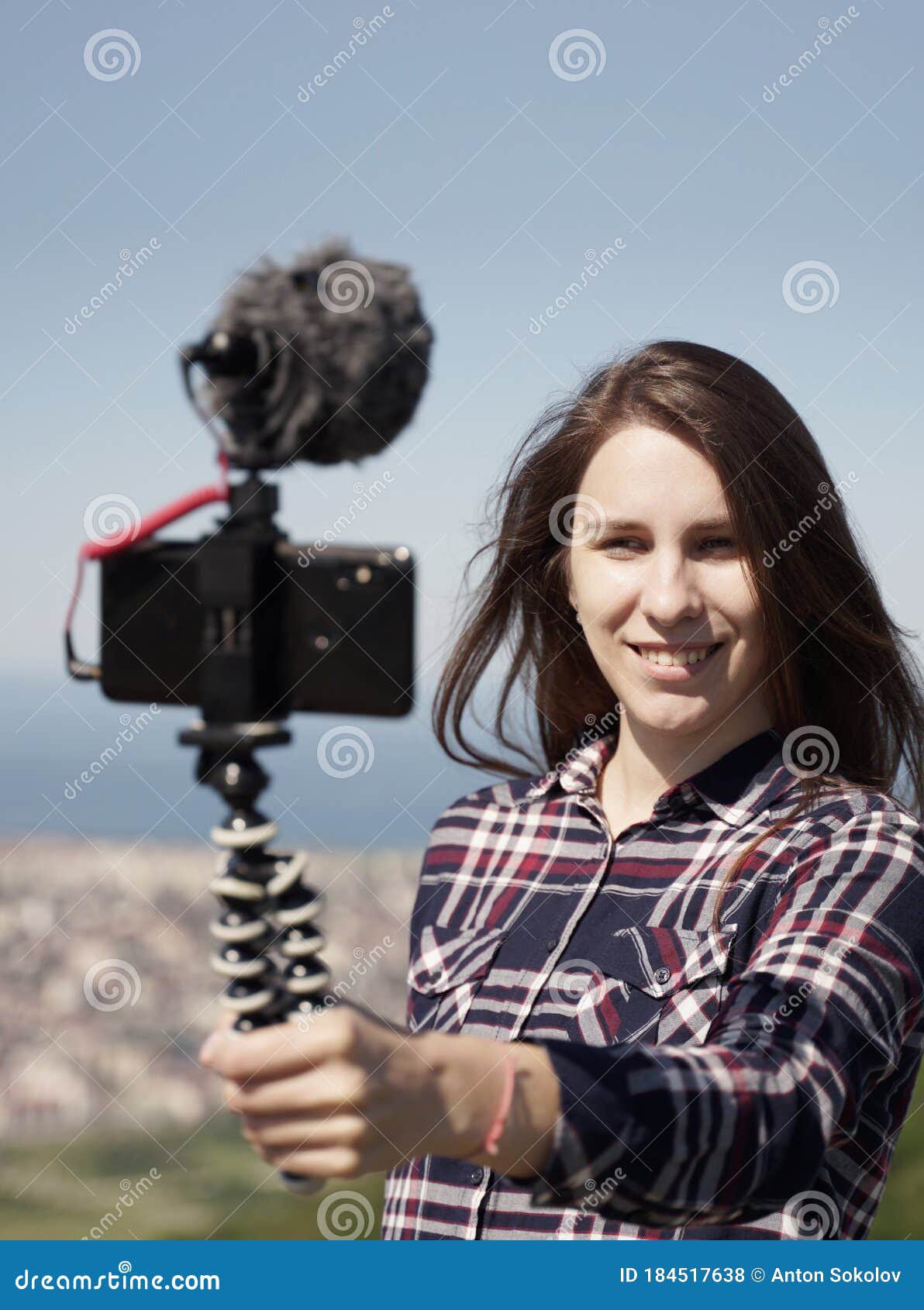 woman vlogging on smartphone from mountain