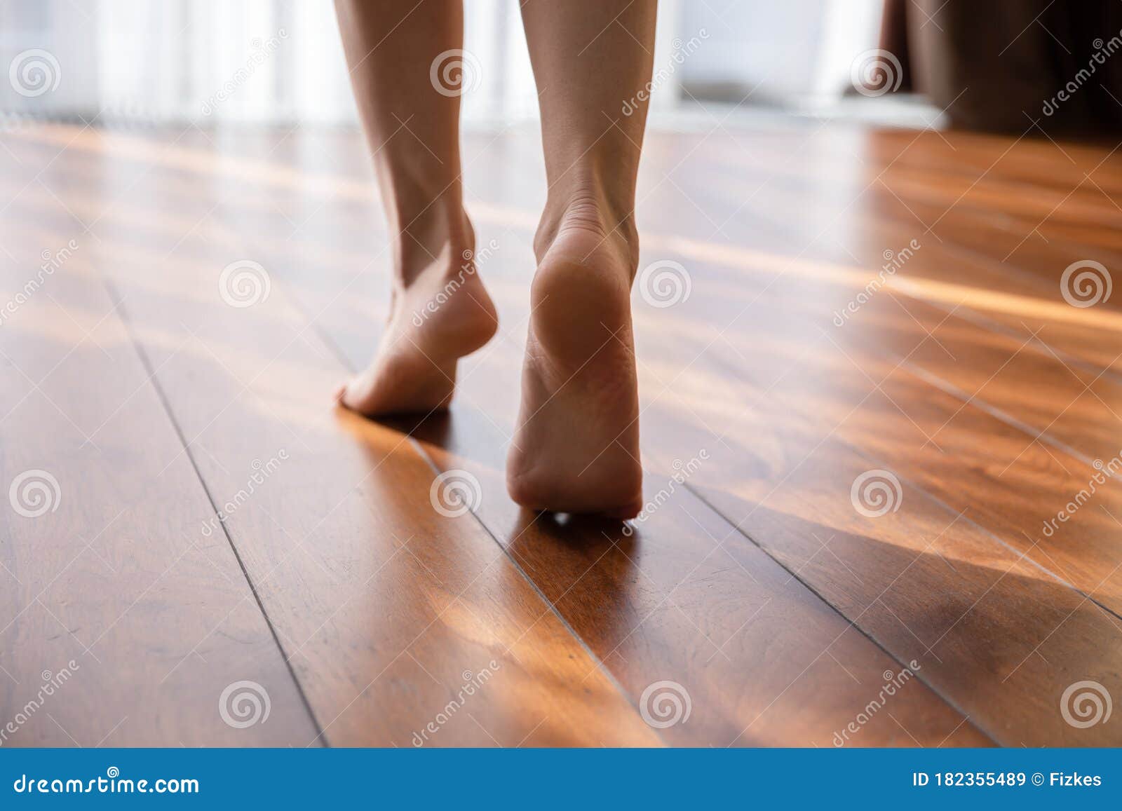 woman walking barefoot on toes at warm floor closeup view