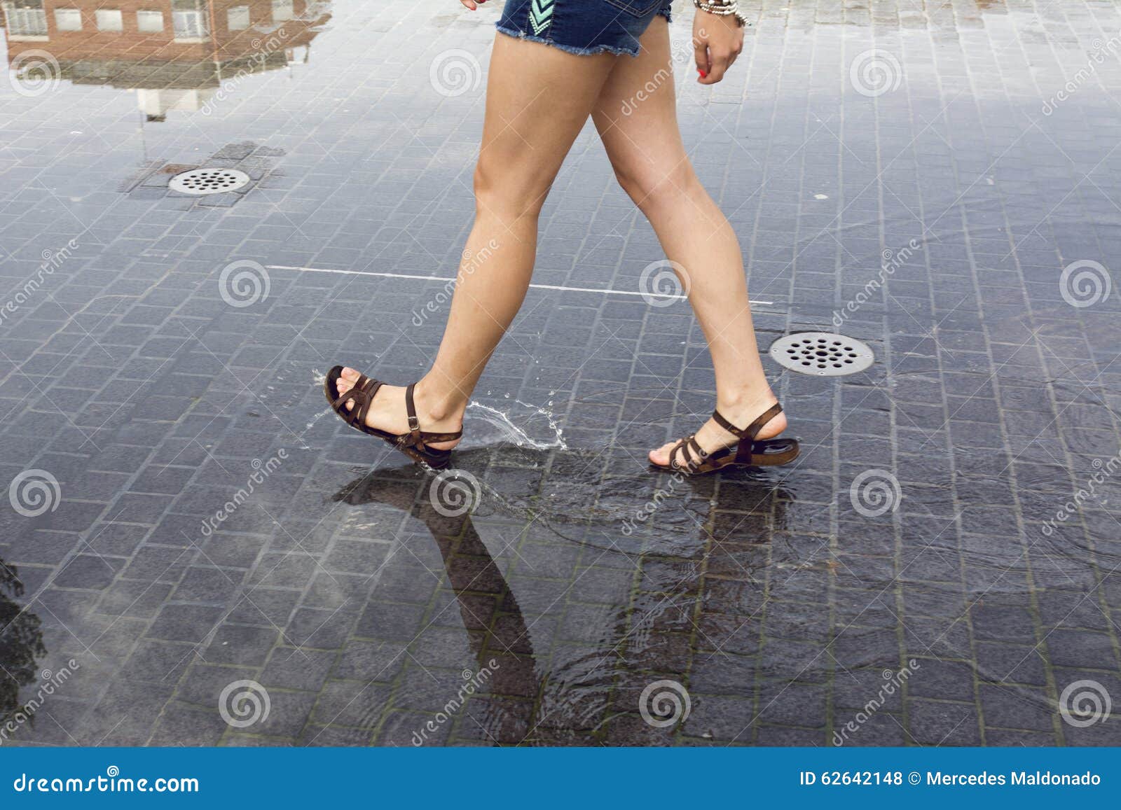 woman walking on a puddle in the street