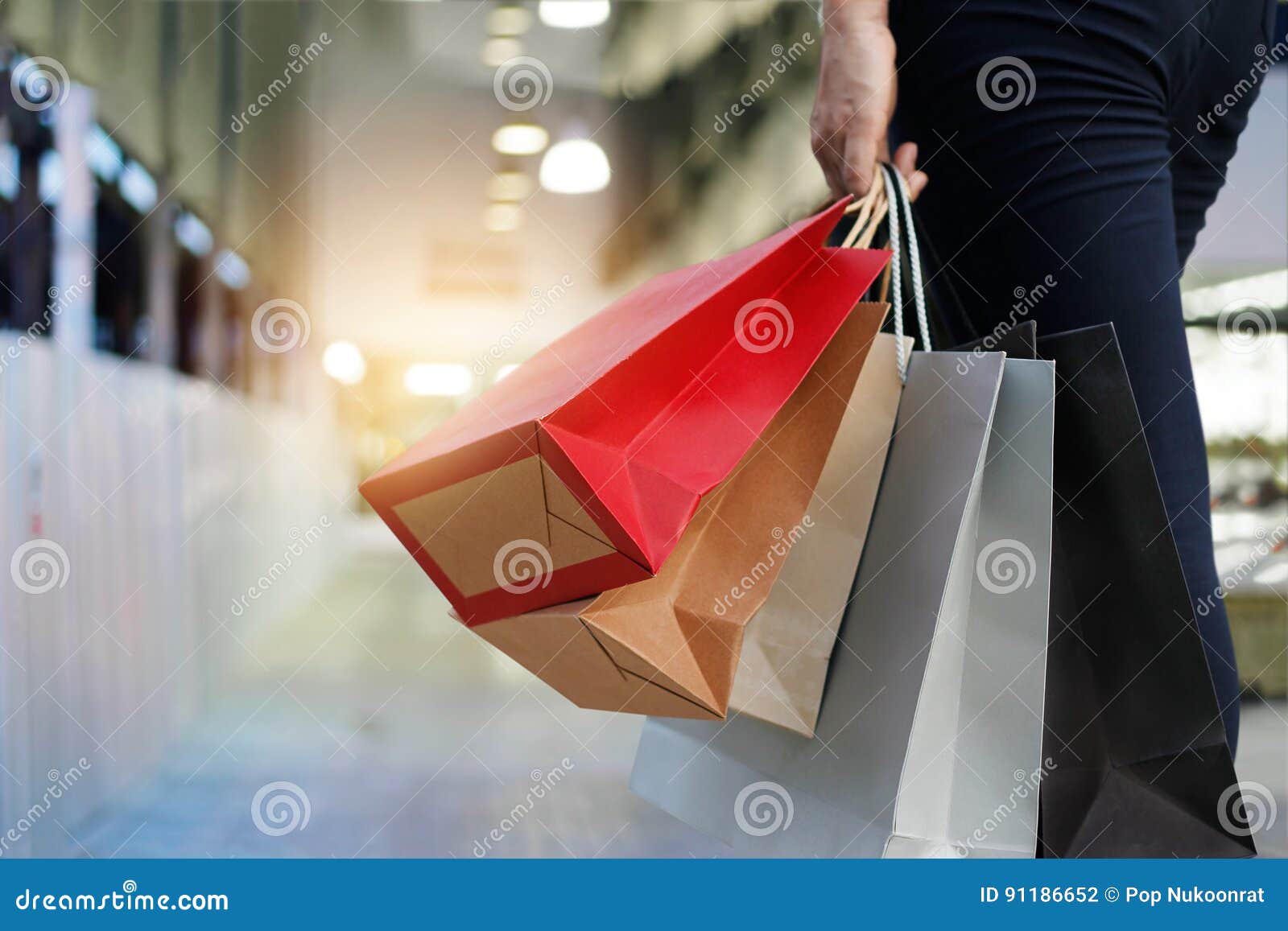 woman walking with shopping bags on shopping mall background