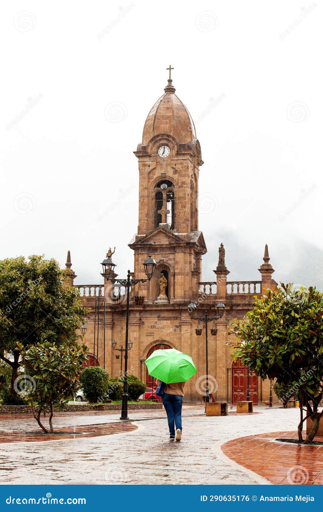 woman walking with an umbrella at the beautiful central square aof the small town of nobsa in a rainy day