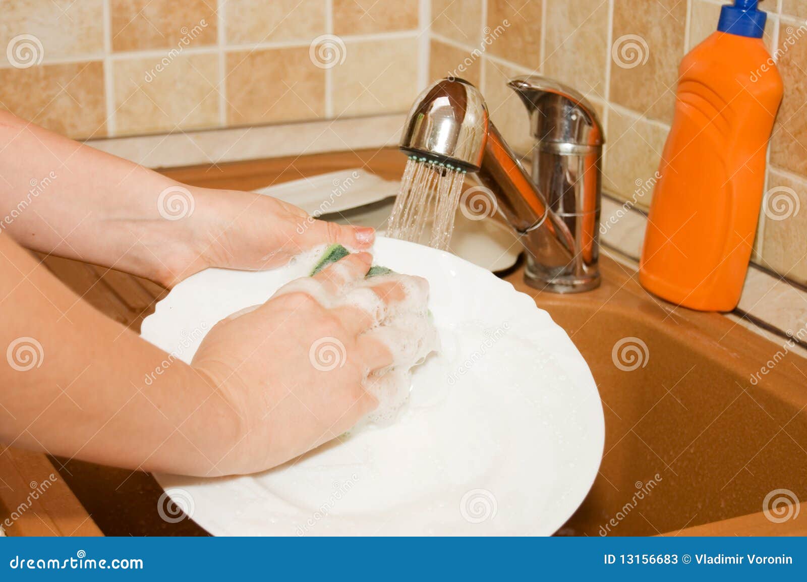 the woman washes ware on kitchen
