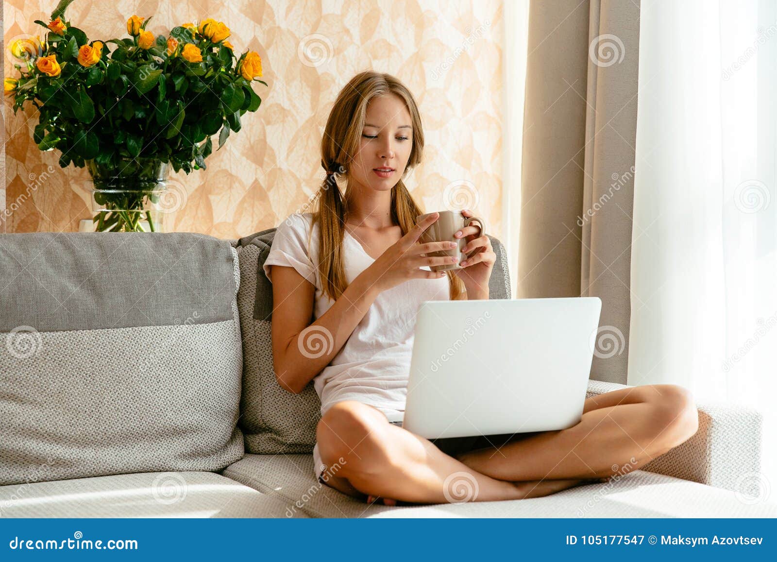 woman watching tv series on laptop on sofa at home