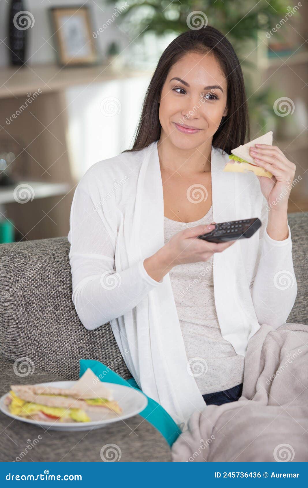 Woman Watching Tv while Eating Sandwich on Sofa Stock Photo Image of