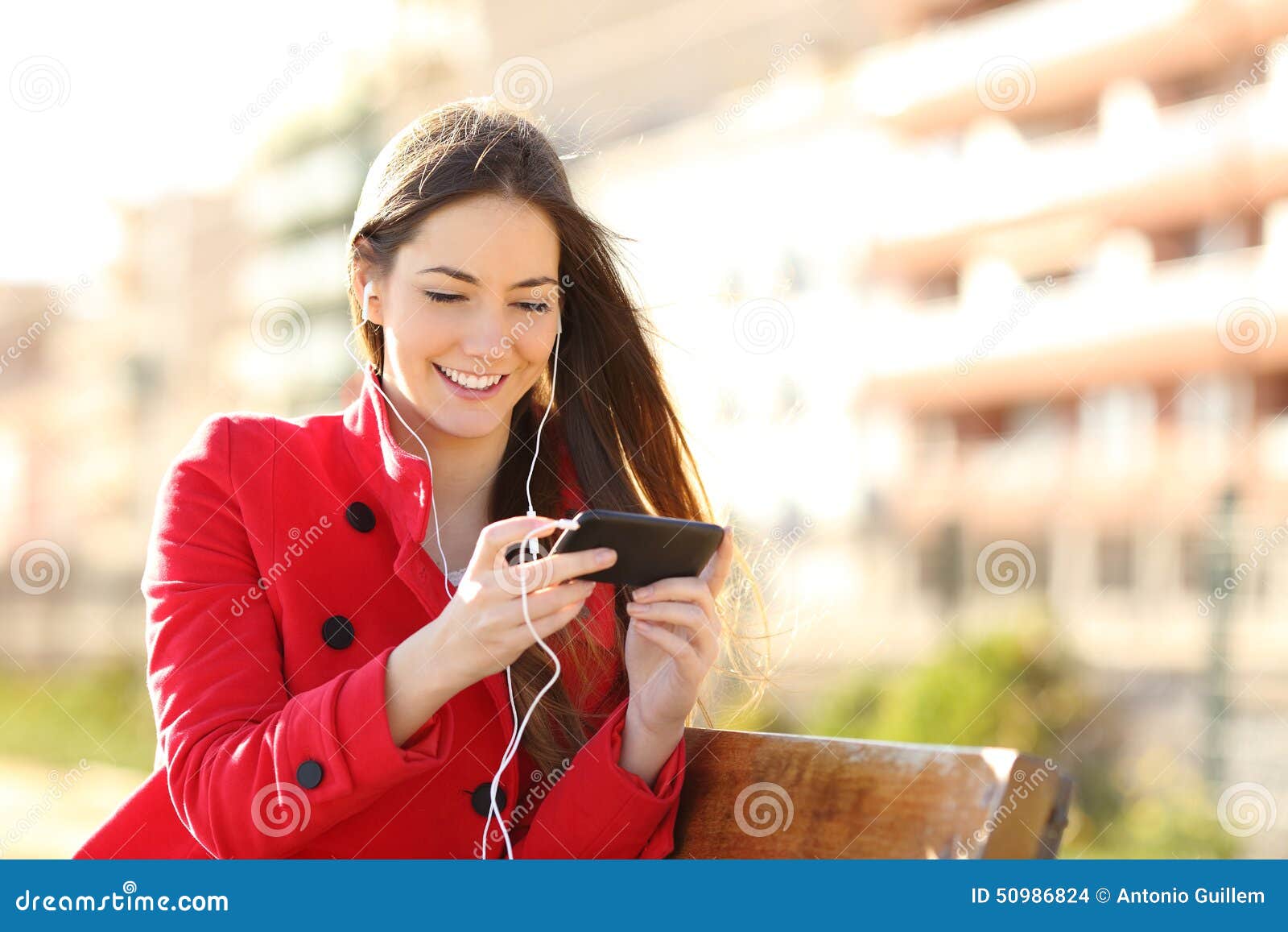 woman watching videos in a smart phone with earphones