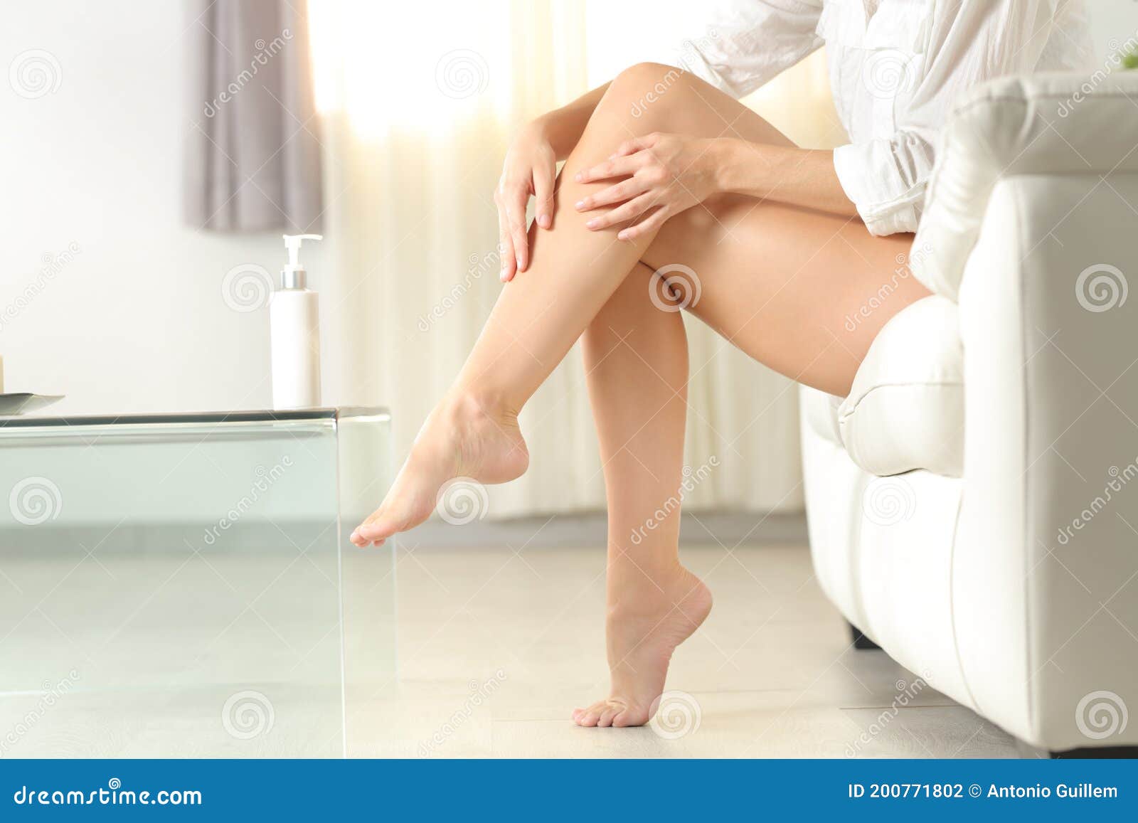 woman with waxed legs aplying moisturizer cream