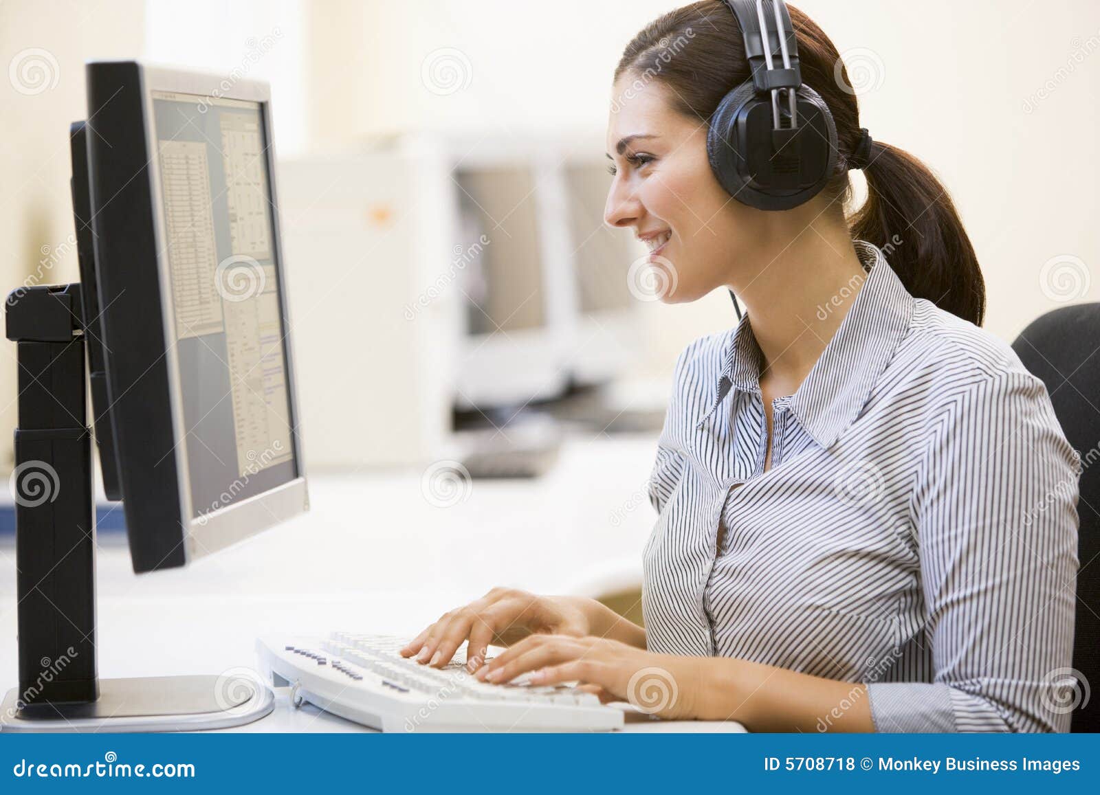 woman wearing headphones in computer room typing