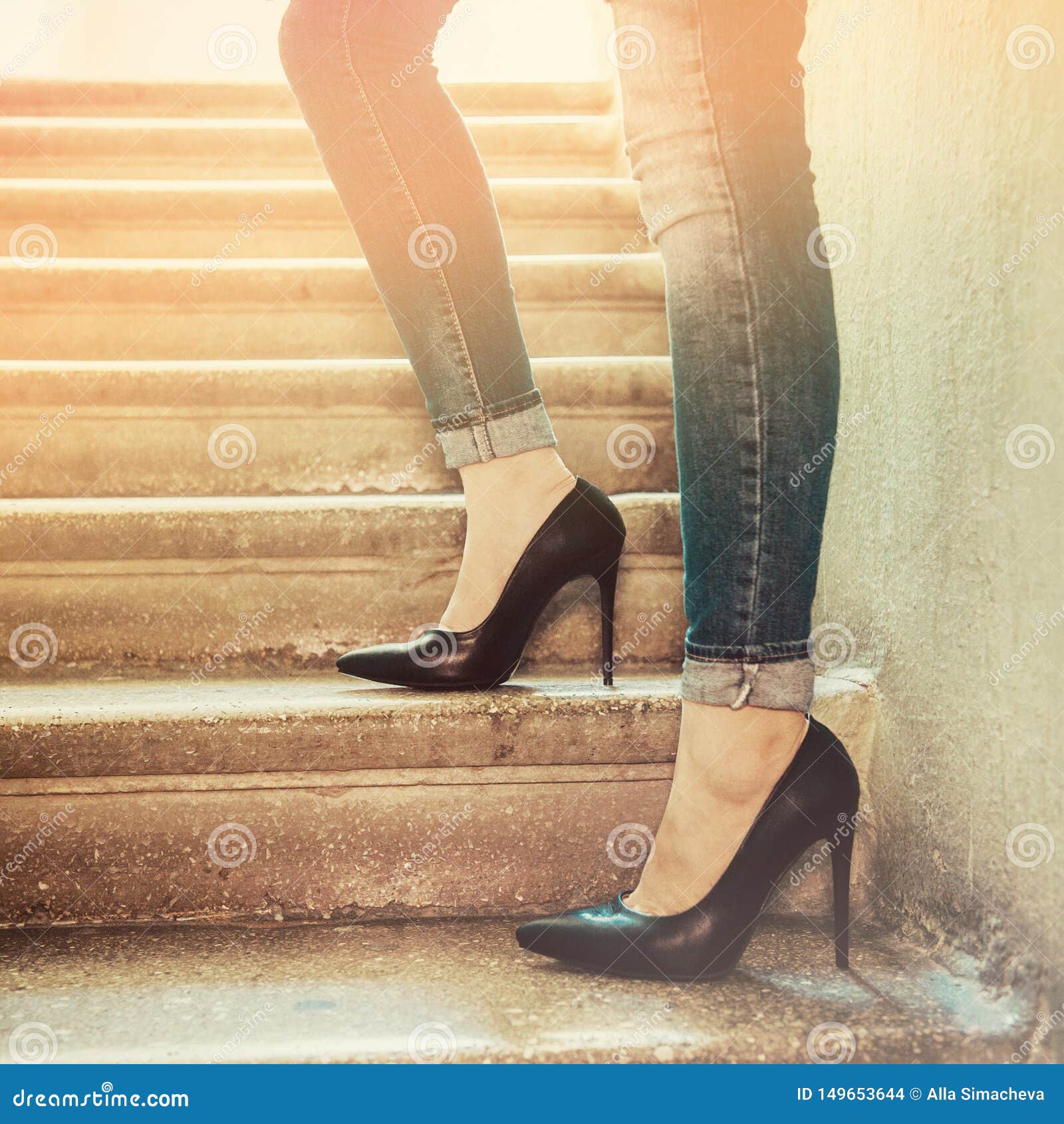 Jeans wearing woman feet with high heels shoes with red sole Stock Photo -  Alamy