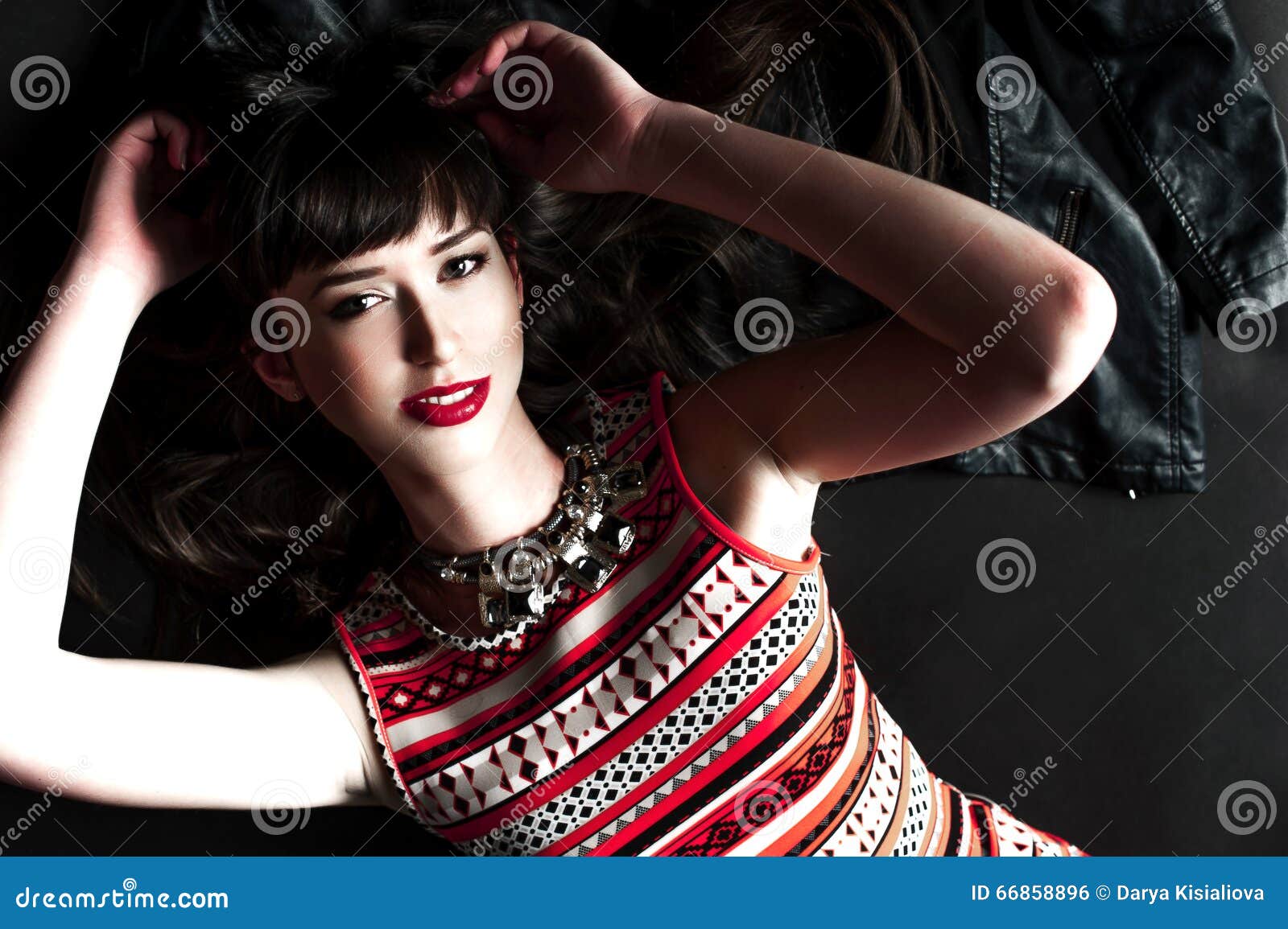 A Woman Wearing a Leather Jacket and Red Dress Stock Photo Image of