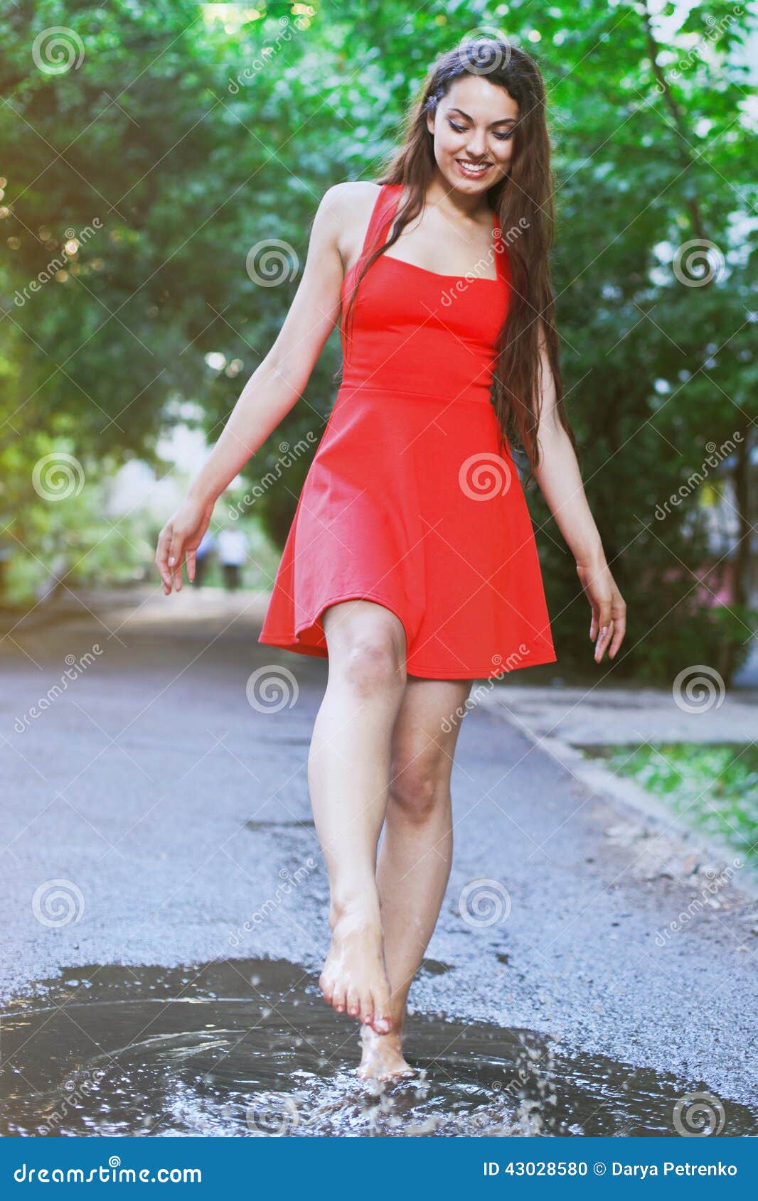 Woman Wearing Red Dress Jumping Into A Puddle After The