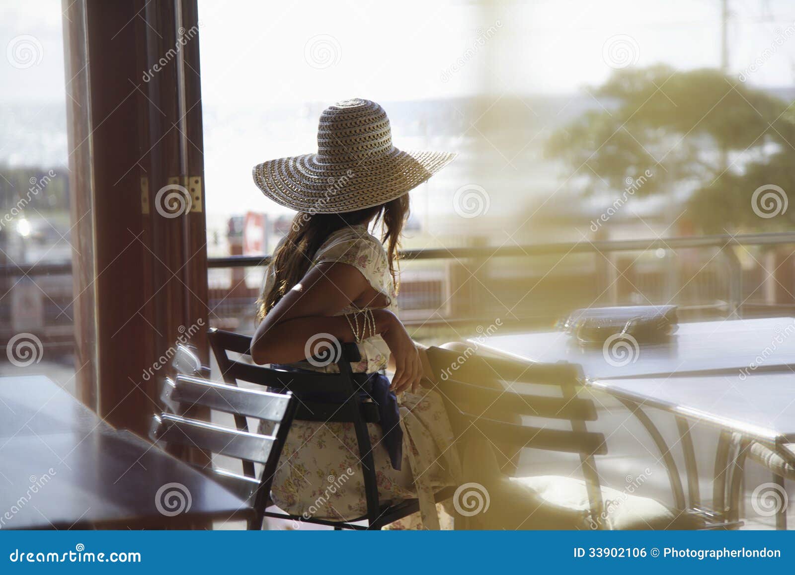woman wearing sunhat at cafe